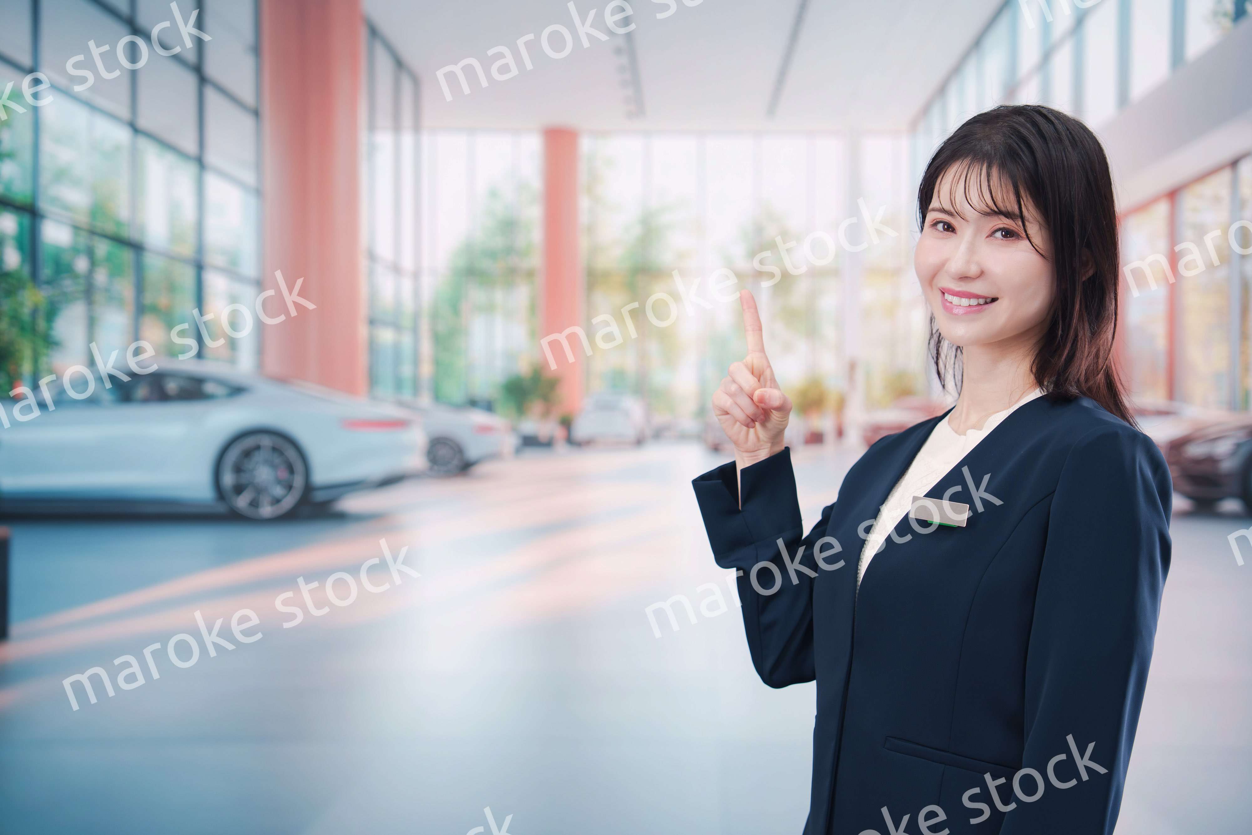 カーディーラーで接客をする若い女性