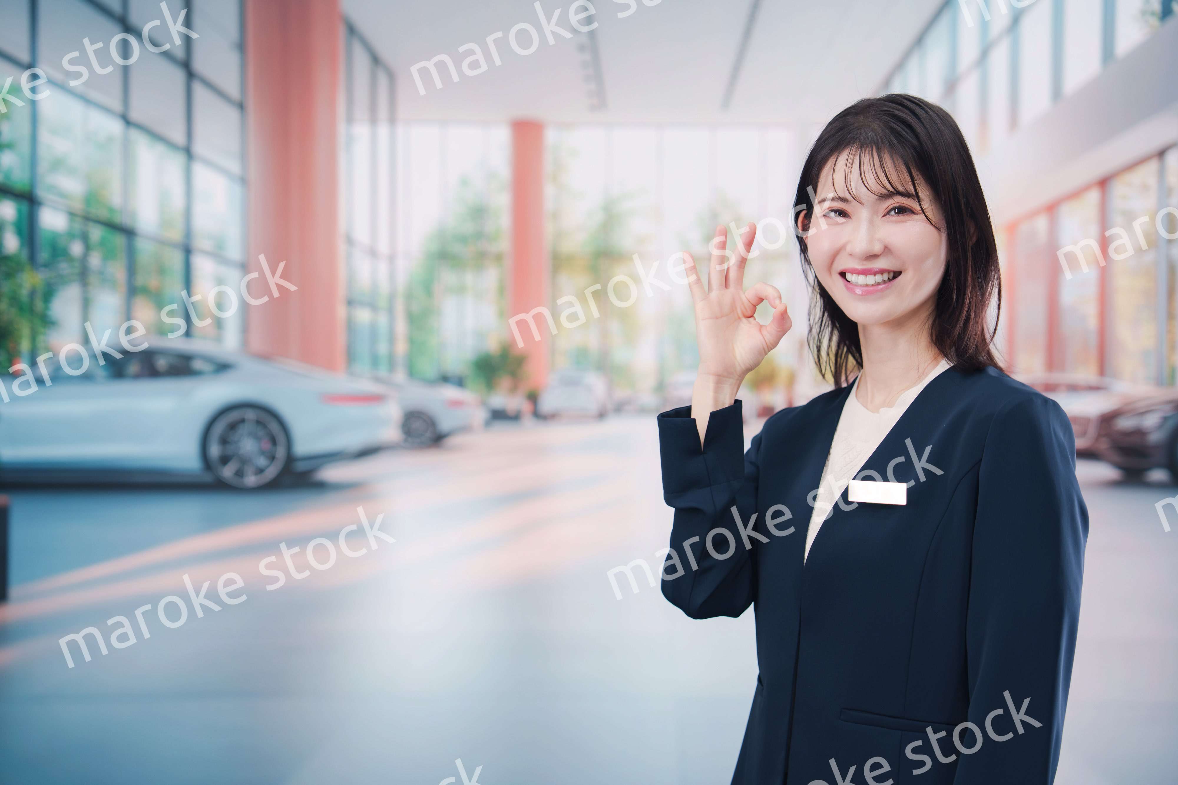カーディーラーで接客をする若い女性