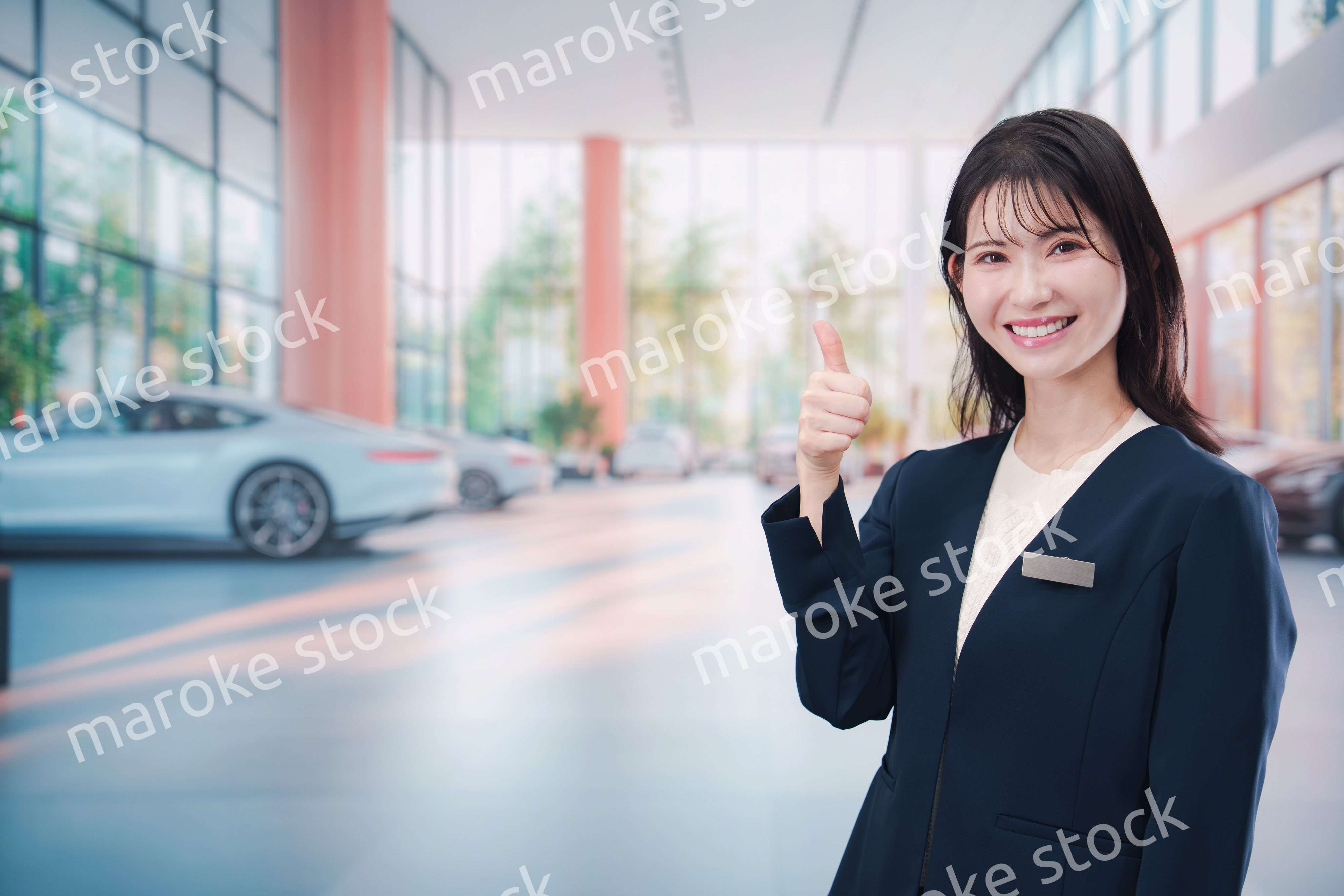 カーディーラーで接客をする若い女性