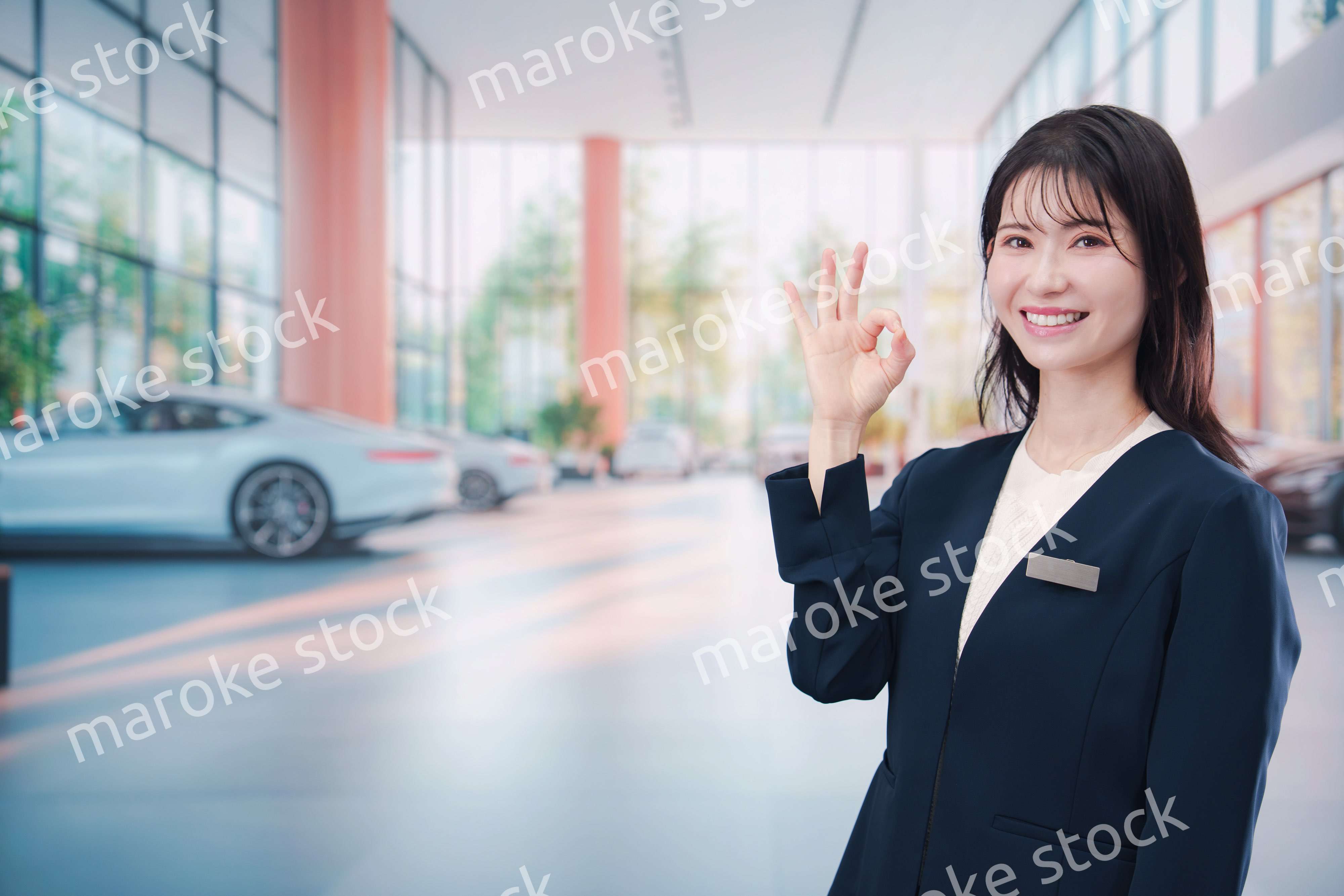 カーディーラーで接客をする若い女性