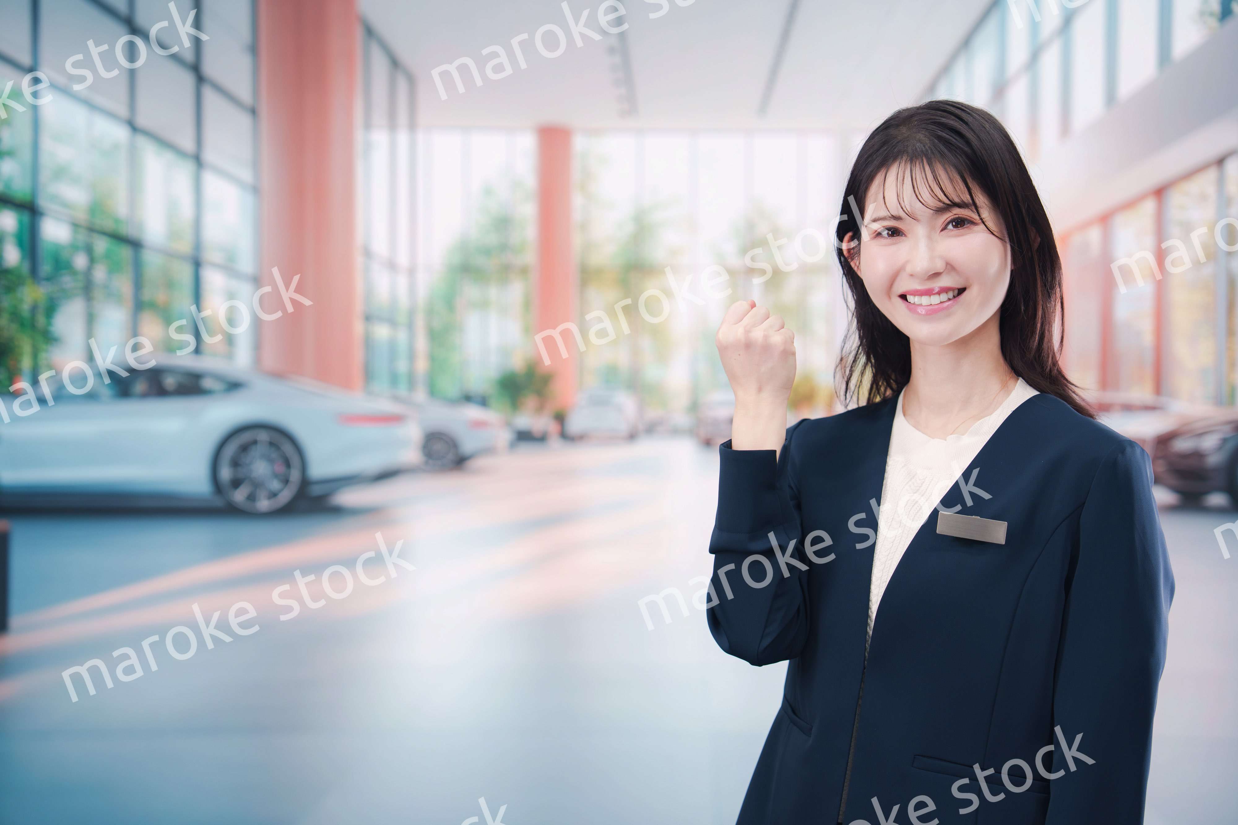 カーディーラーで接客をする若い女性
