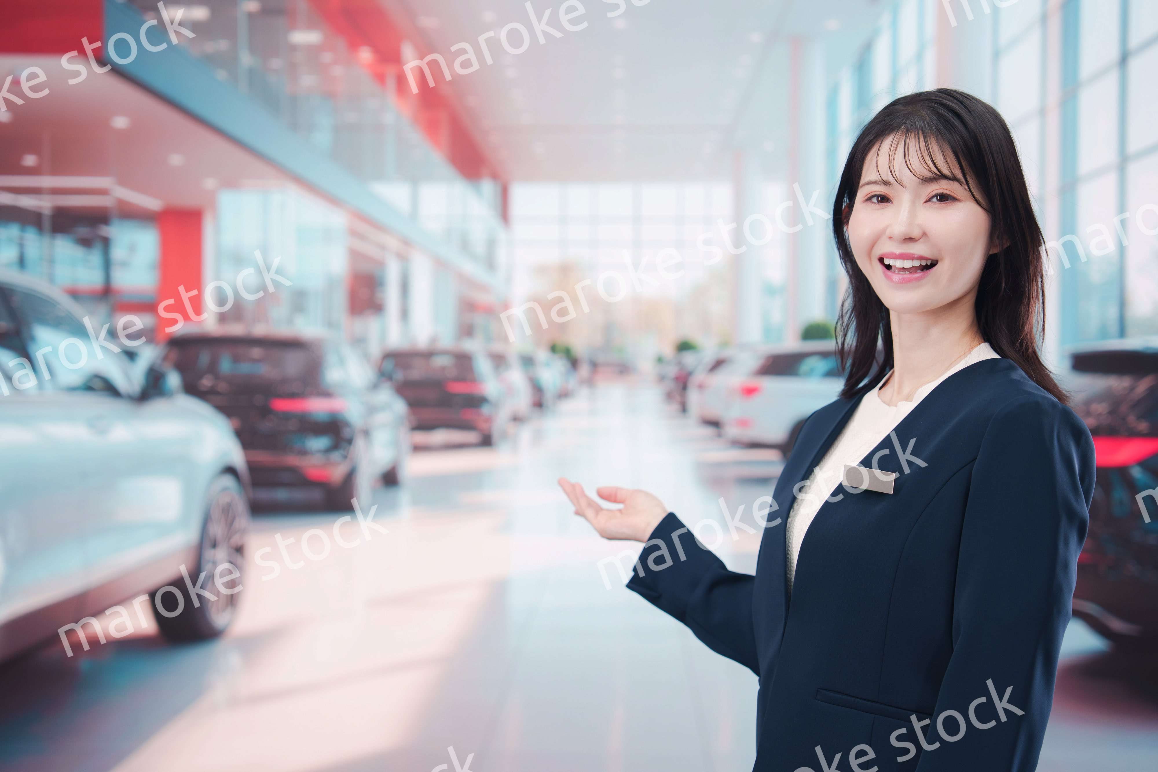 カーディーラーで接客をする若い女性