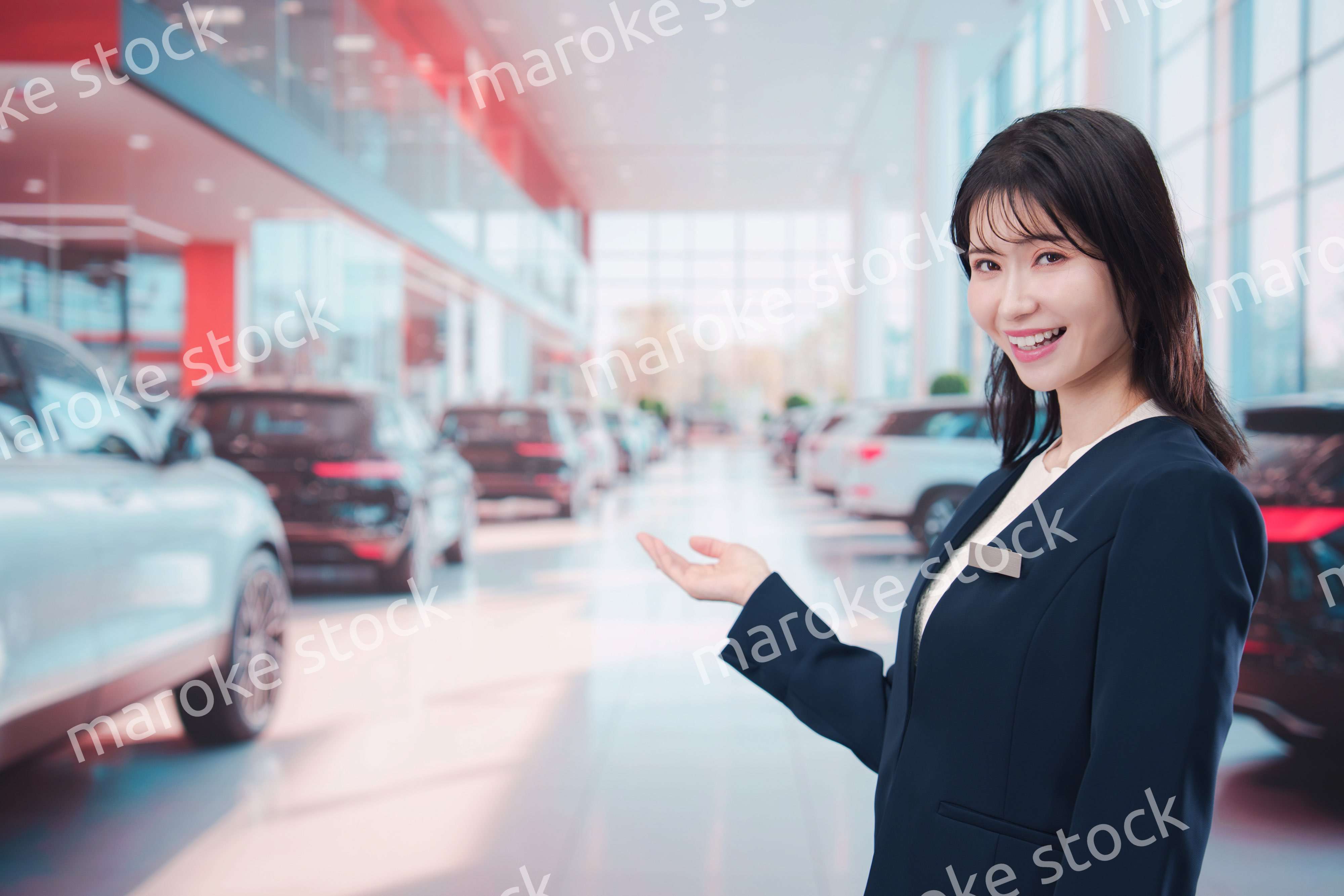 カーディーラーで接客をする若い女性