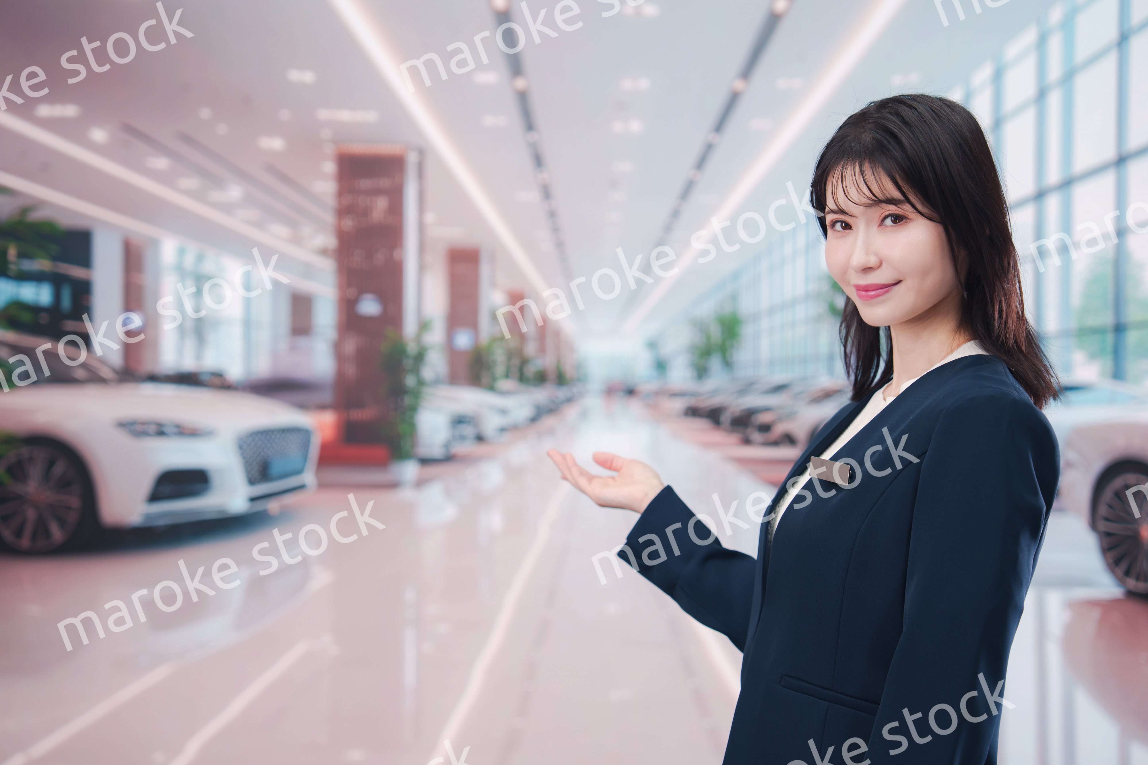 カーディーラーで接客をする若い女性