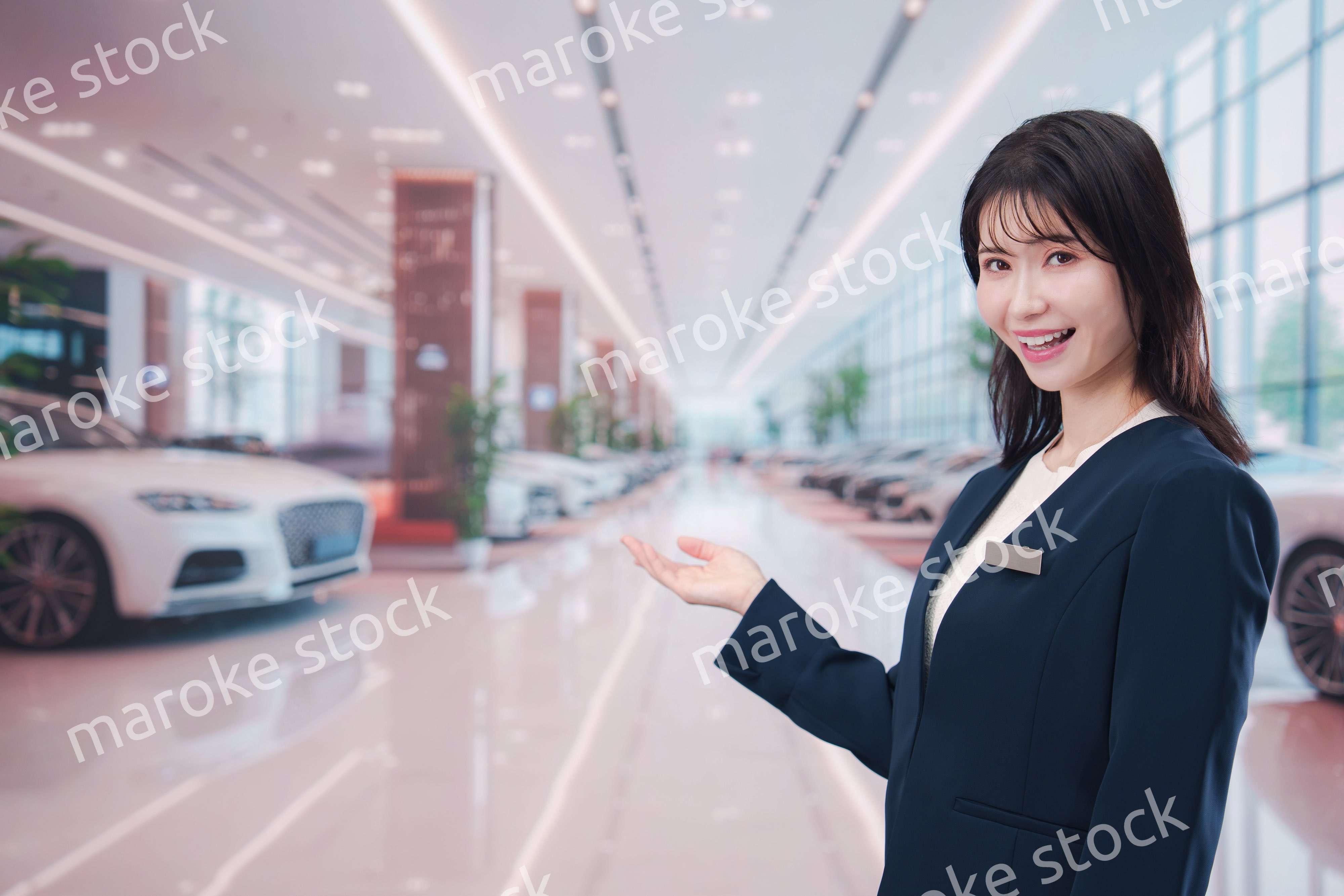 カーディーラーで接客をする若い女性