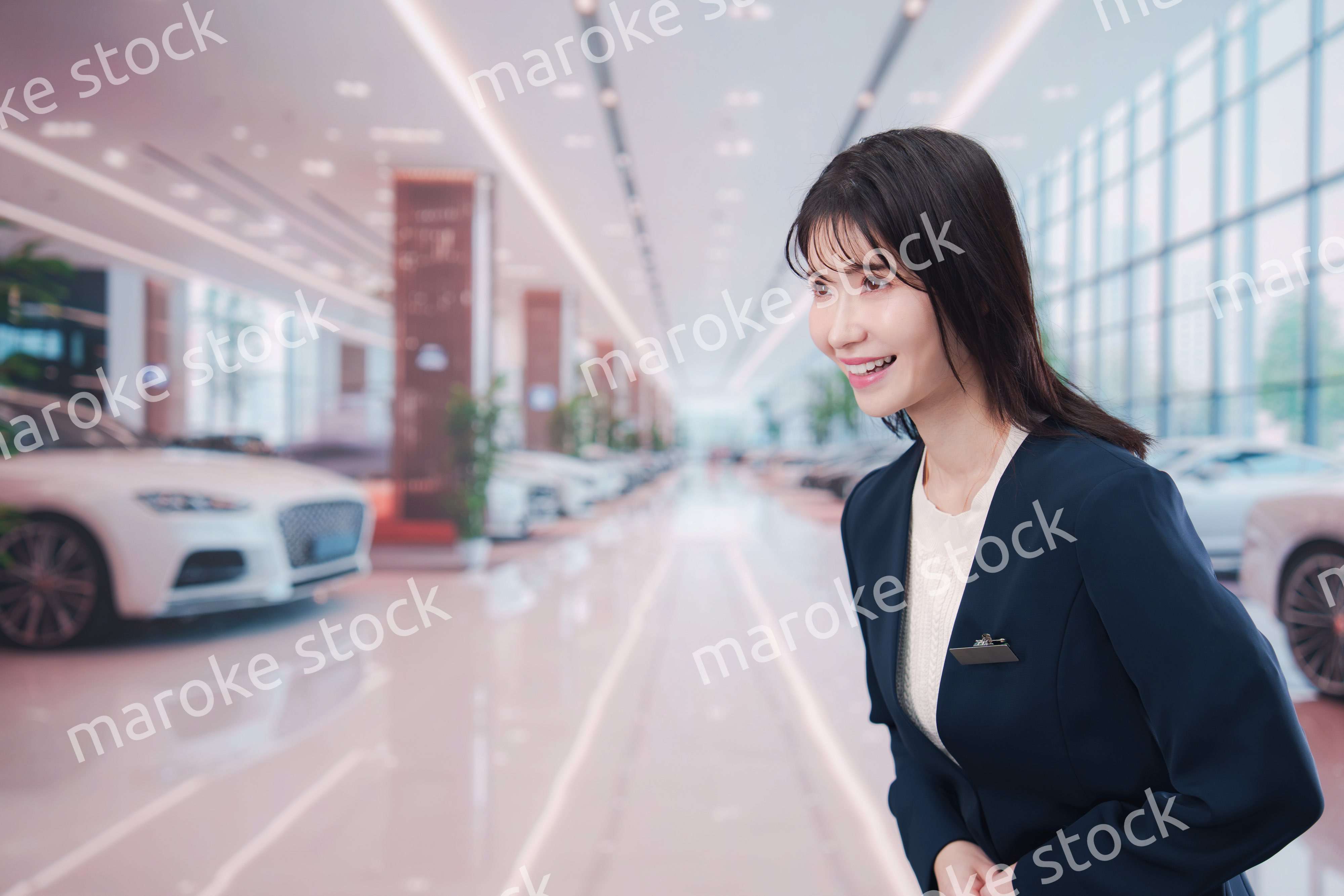 カーディーラーで接客をする若い女性