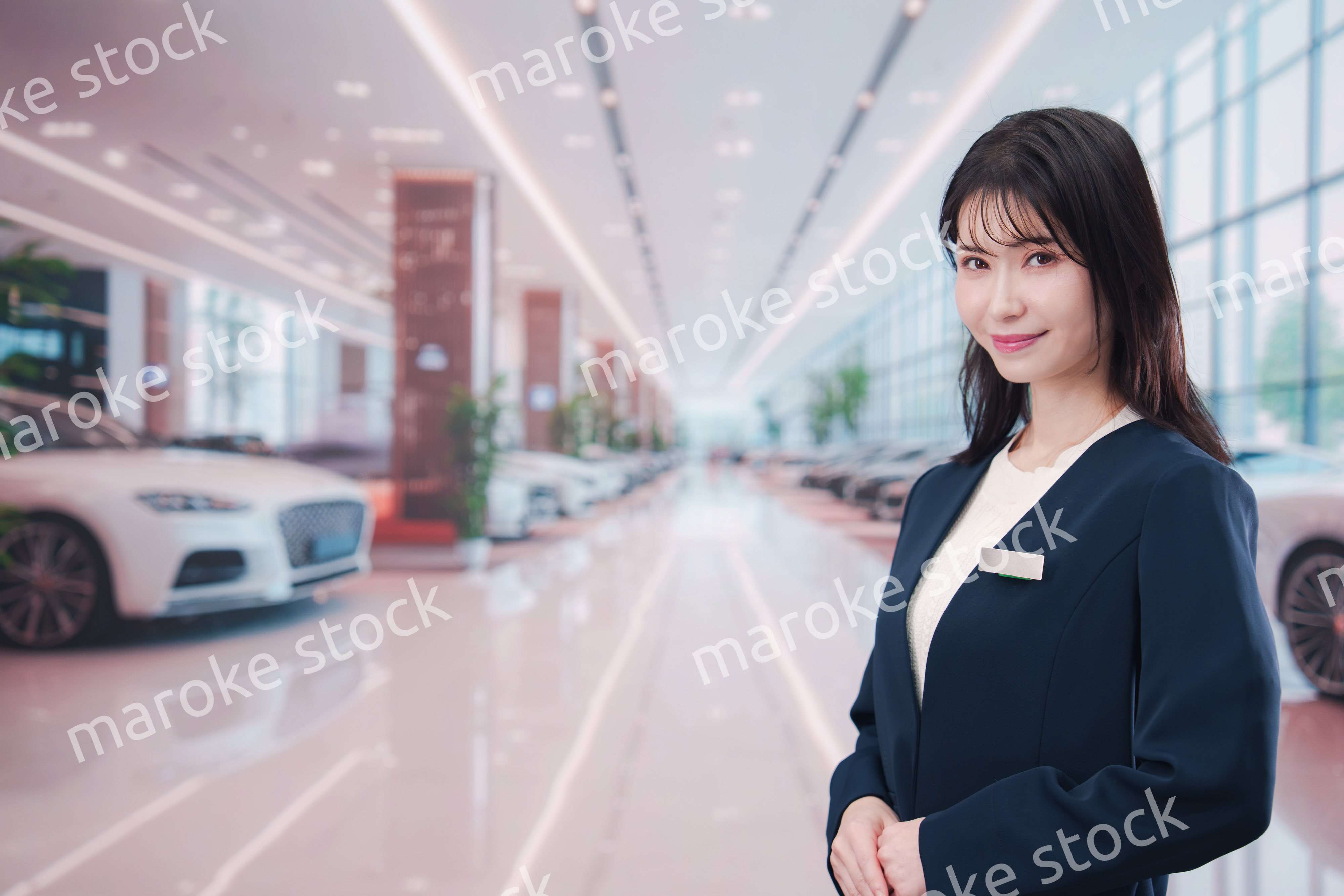 カーディーラーで接客をする若い女性