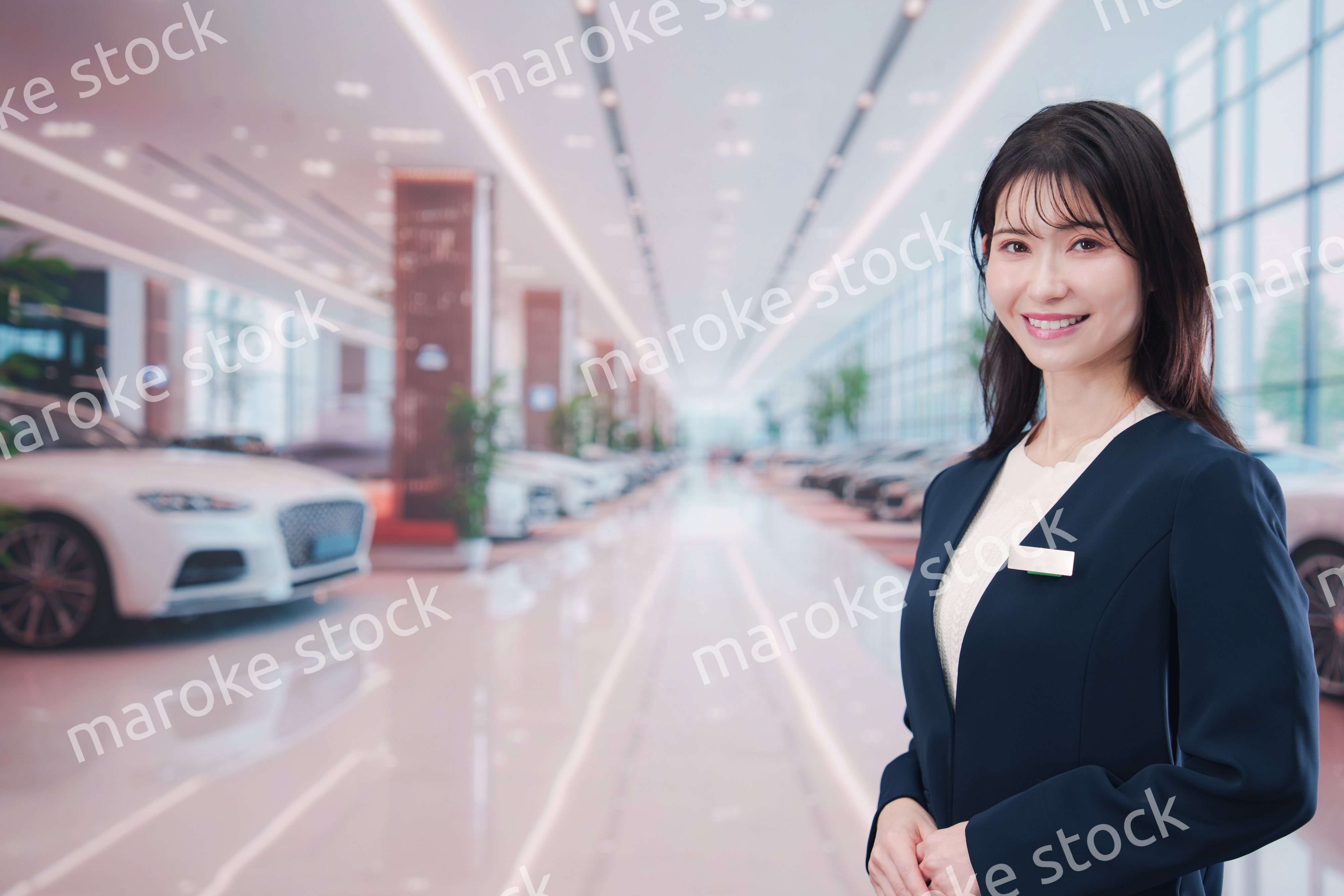 カーディーラーで接客をする若い女性