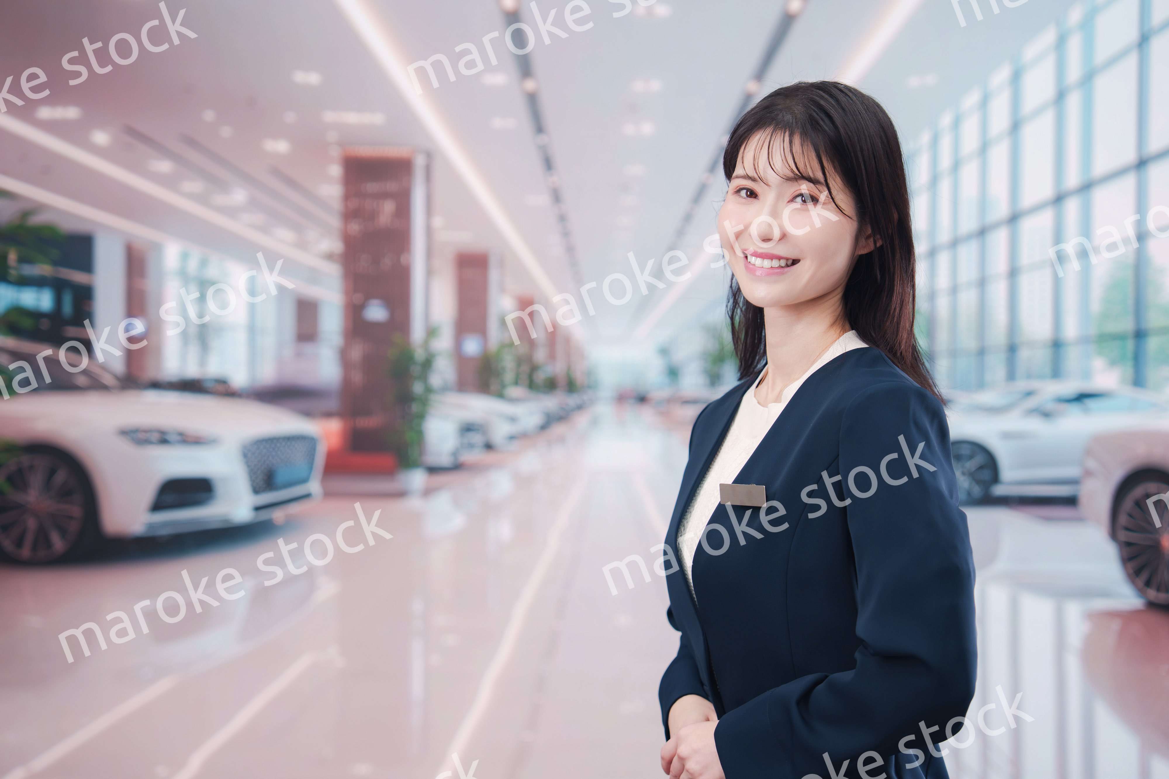 カーディーラーで接客をする若い女性
