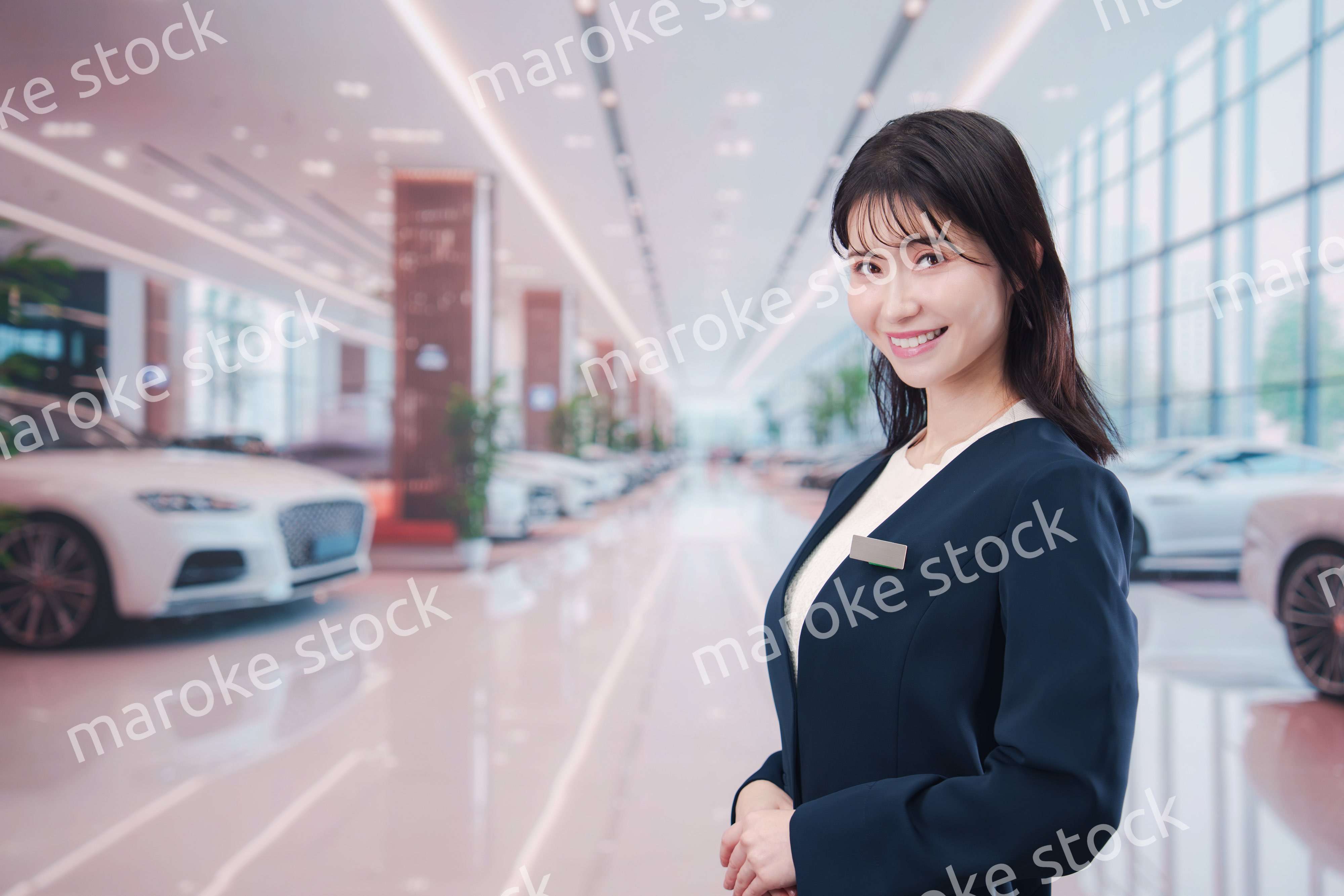 カーディーラーで接客をする若い女性