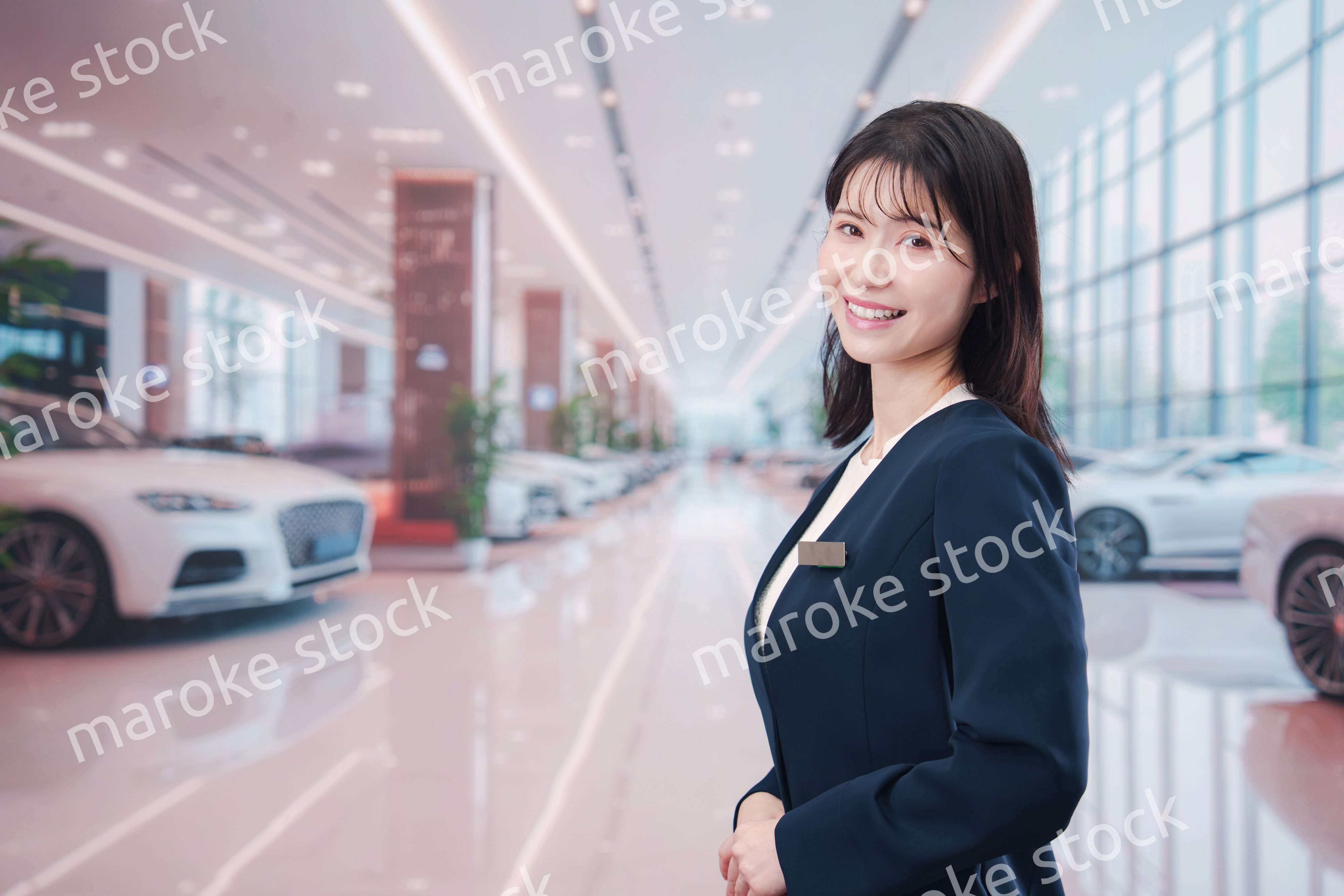 カーディーラーで接客をする若い女性