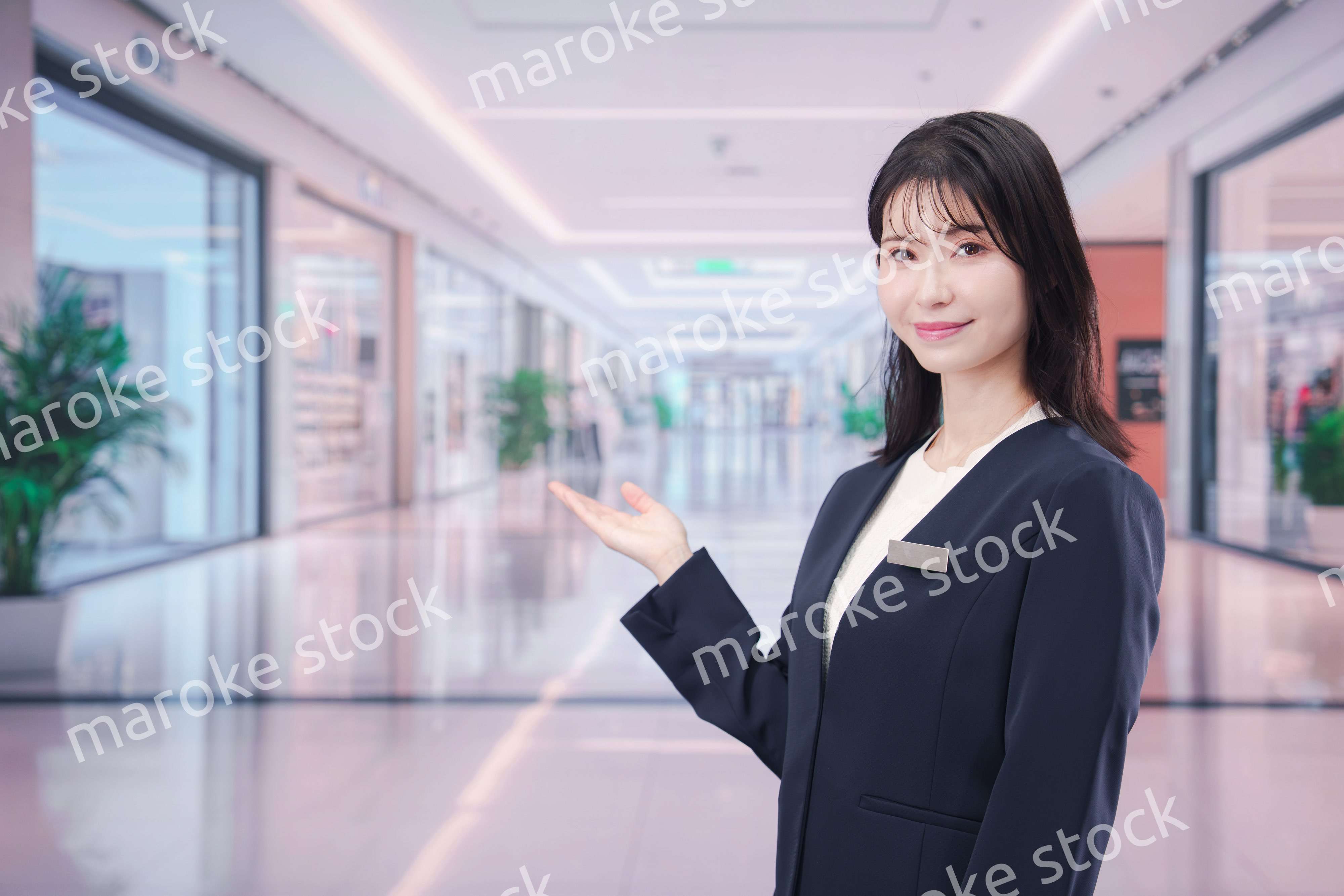 ショッピングモールで案内をするスタッフの女性