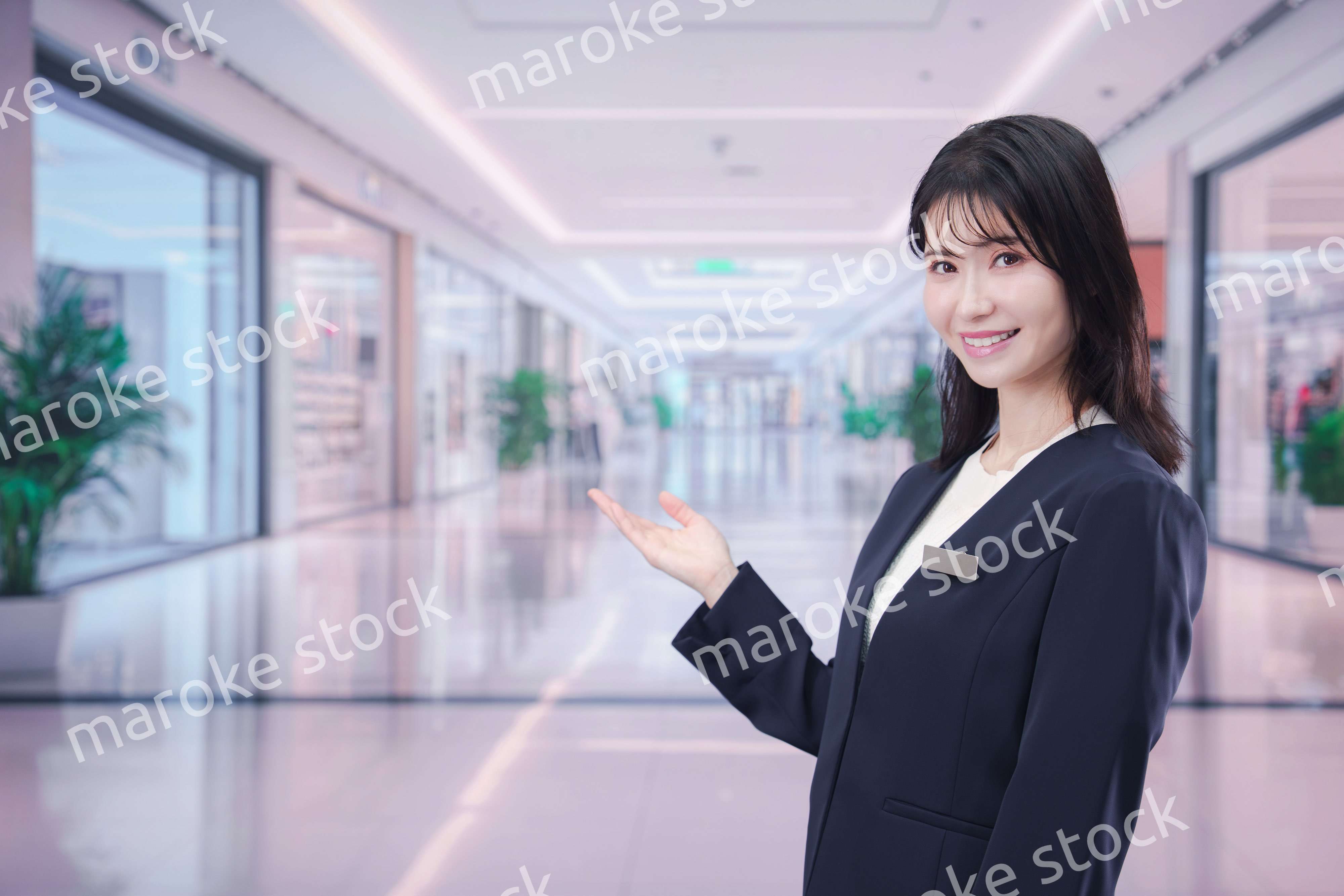 ショッピングモールで案内をするスタッフの女性