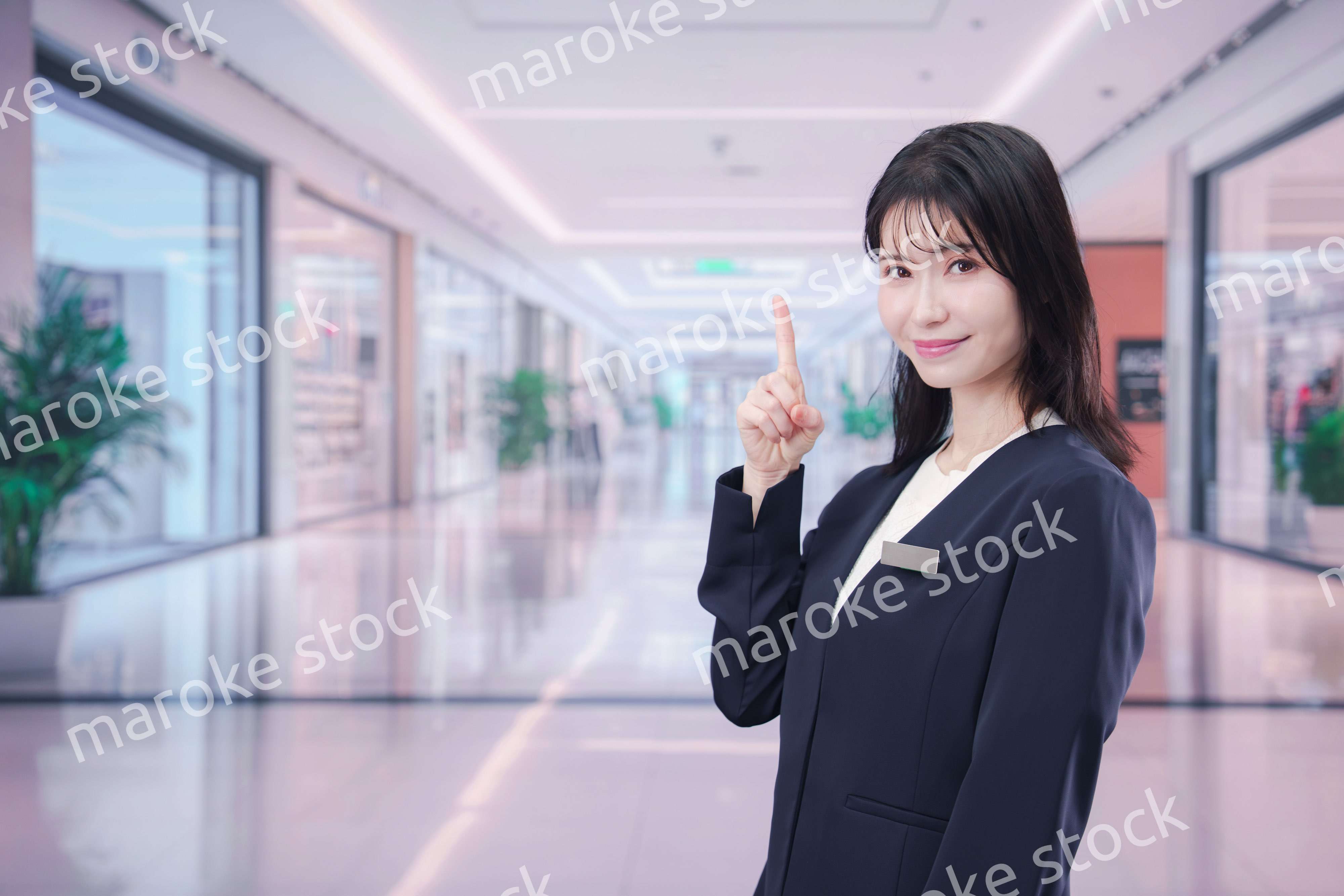 ショッピングモールで案内をするスタッフの女性