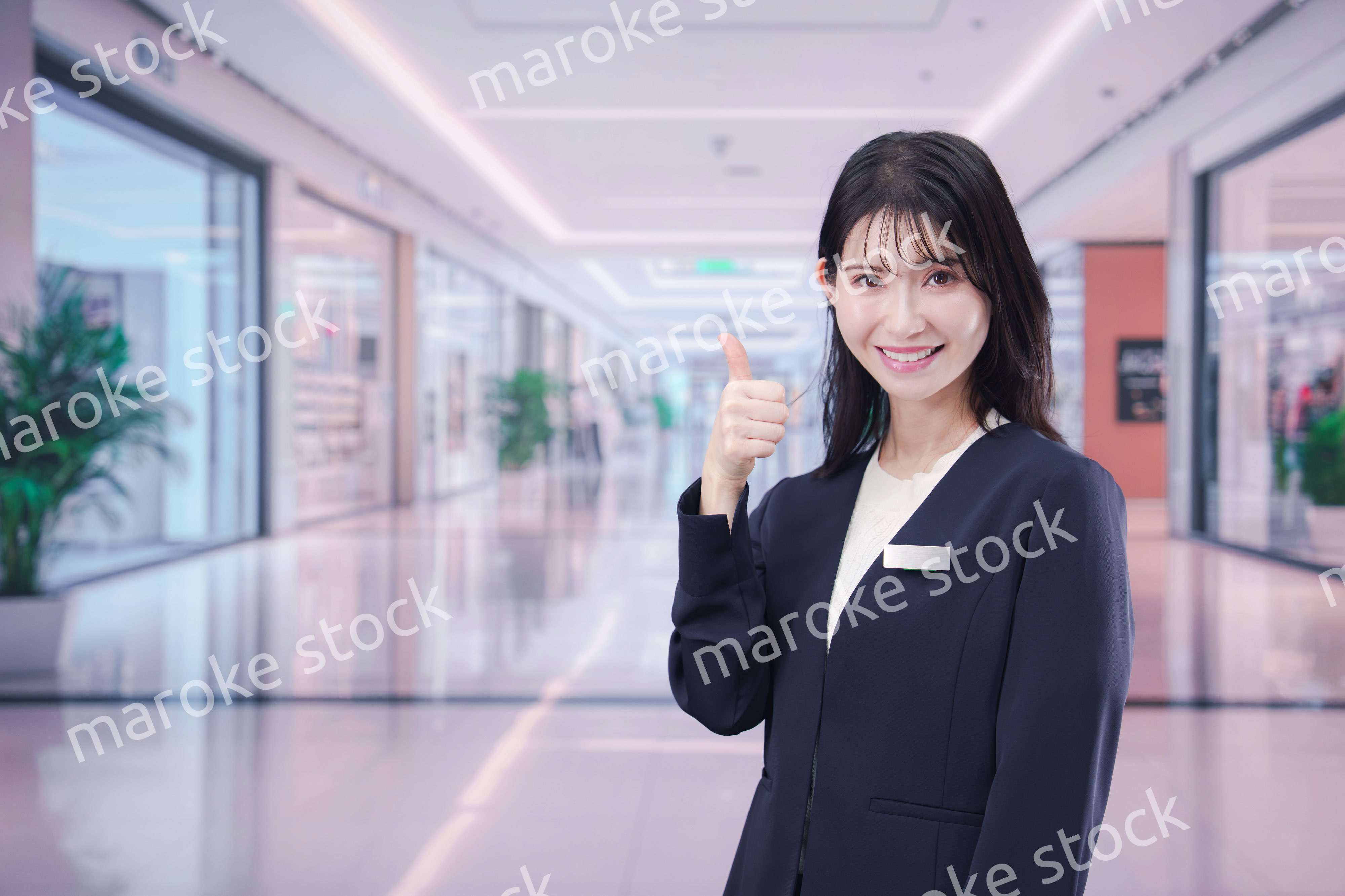 ショッピングモールで案内をするスタッフの女性