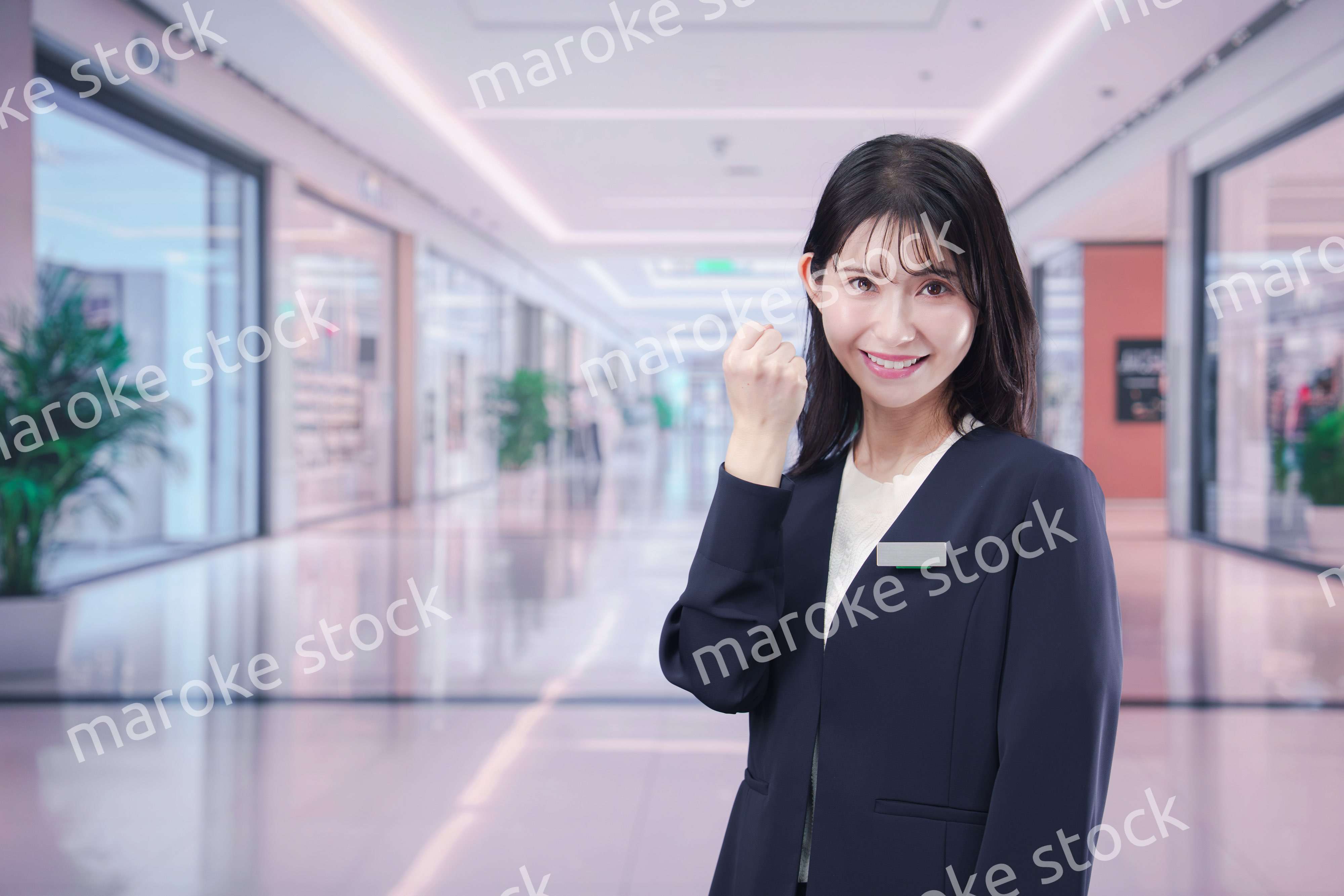 ショッピングモールで案内をするスタッフの女性