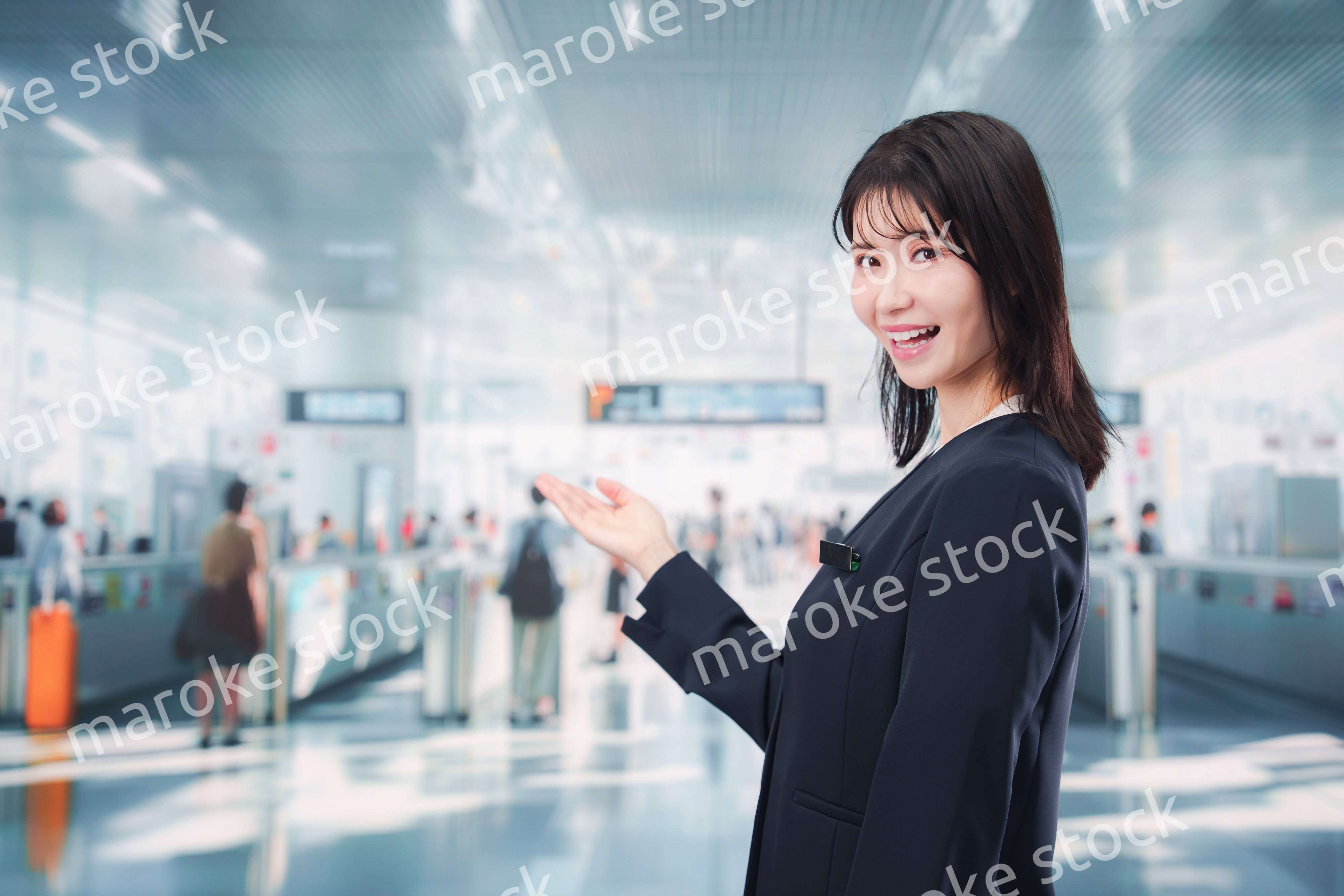 駅で案内をする若い女性のスタッフ