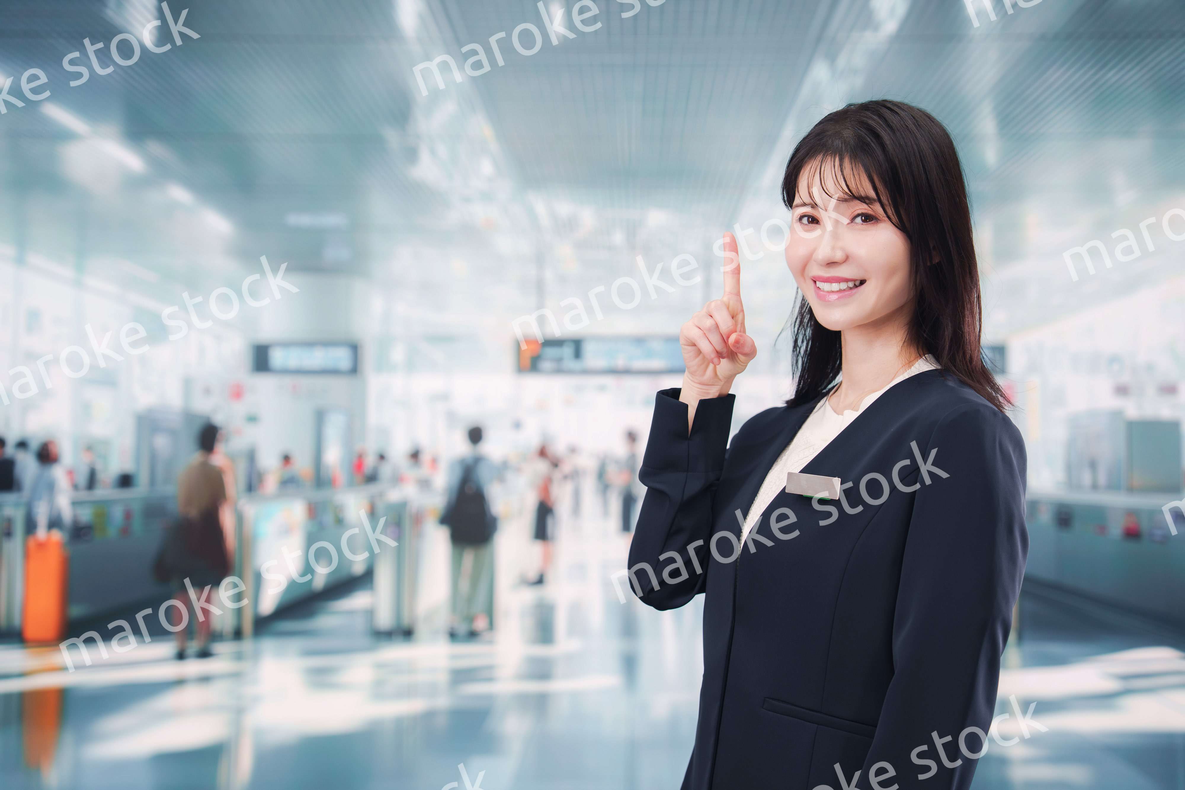 駅で案内をする若い女性のスタッフ