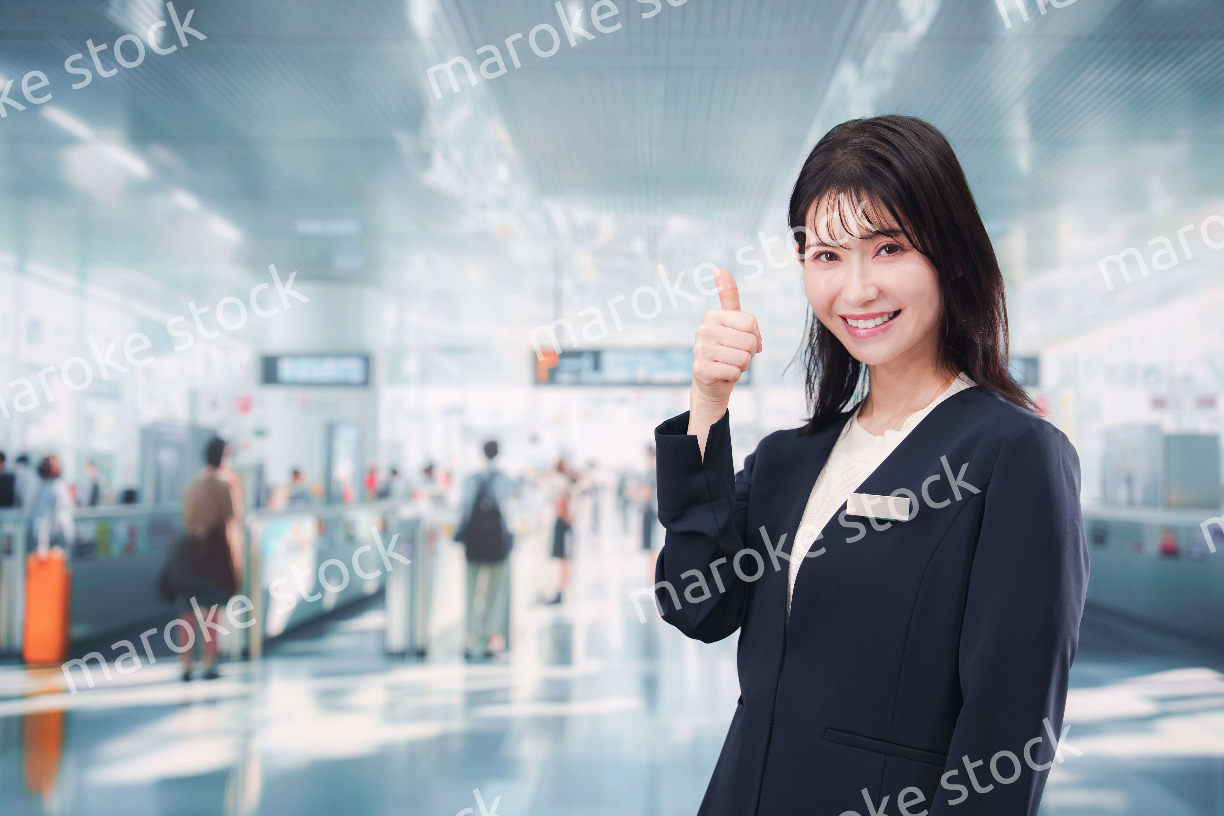 駅で案内をする若い女性のスタッフ