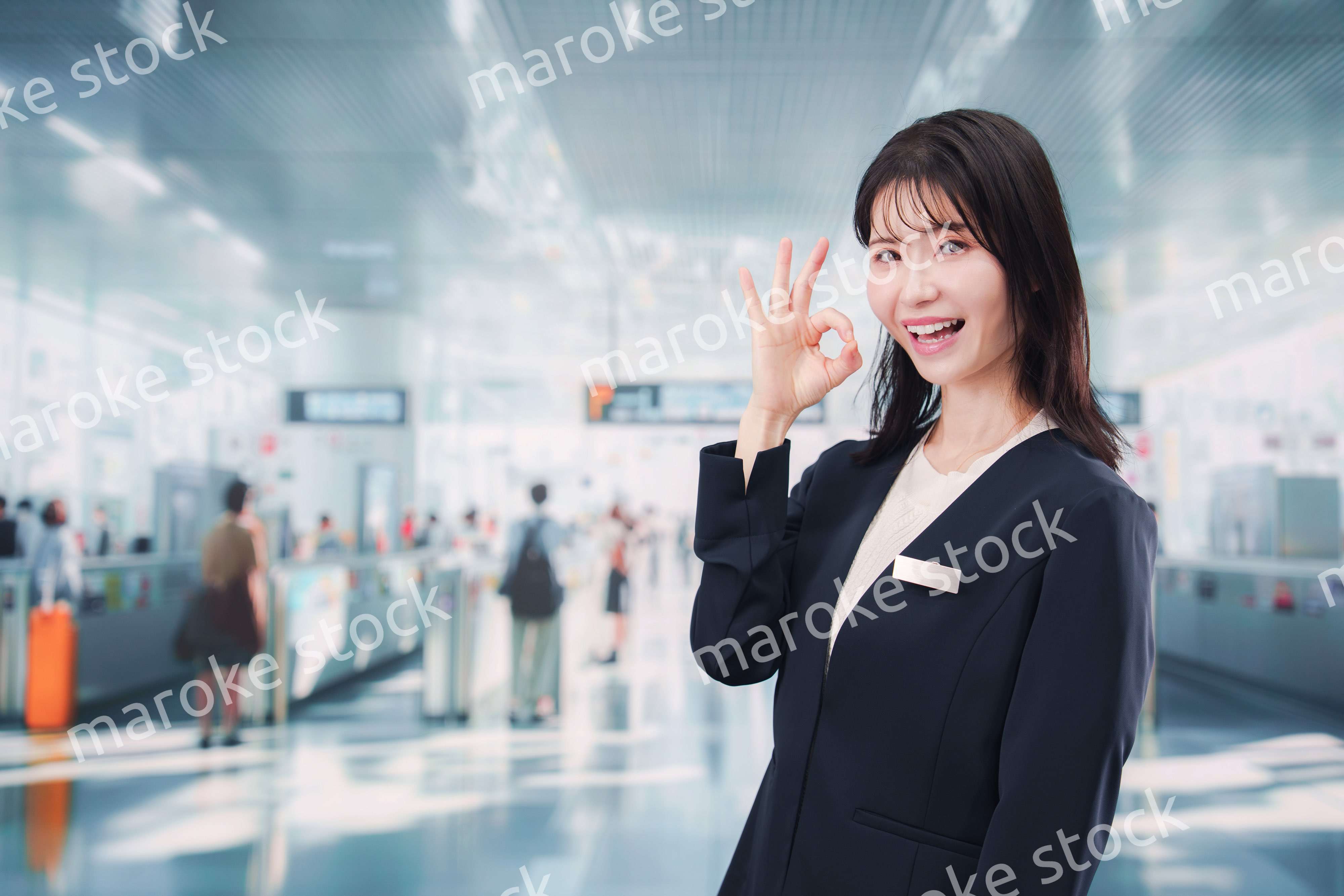 駅で案内をする若い女性のスタッフ