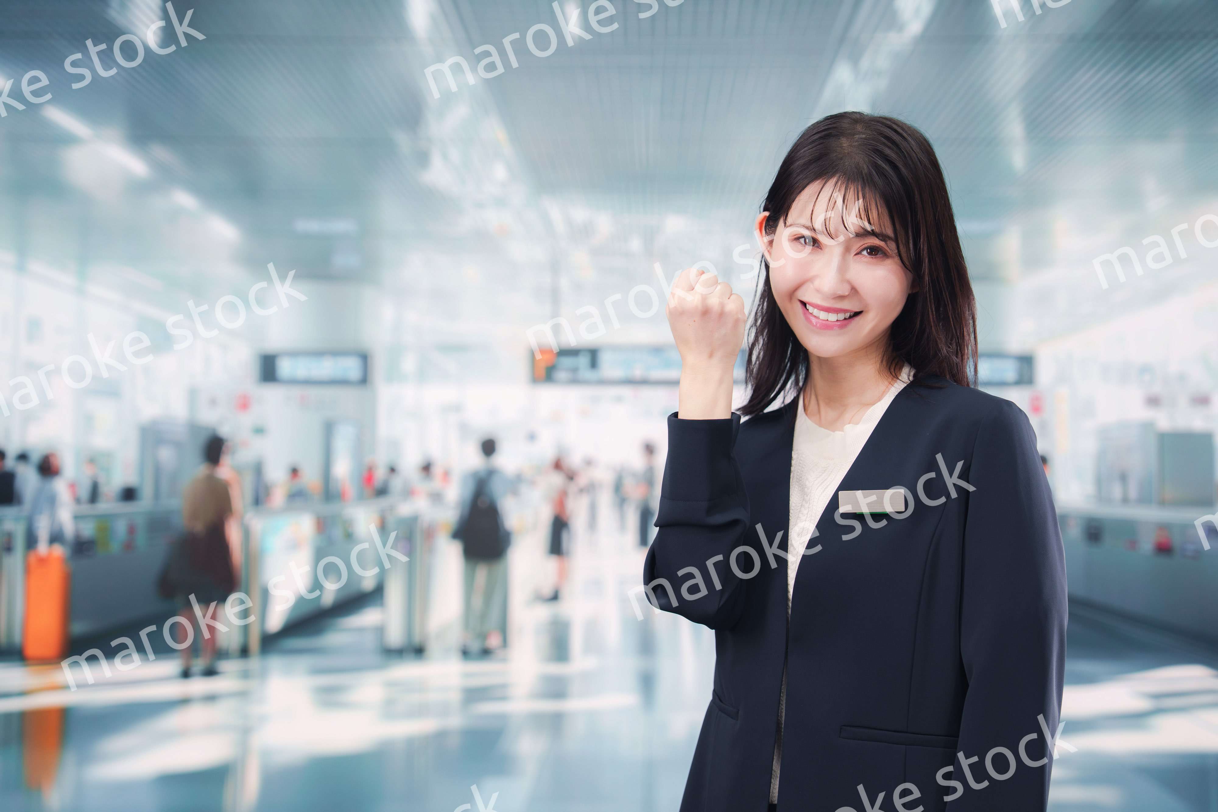 駅で案内をする若い女性のスタッフ