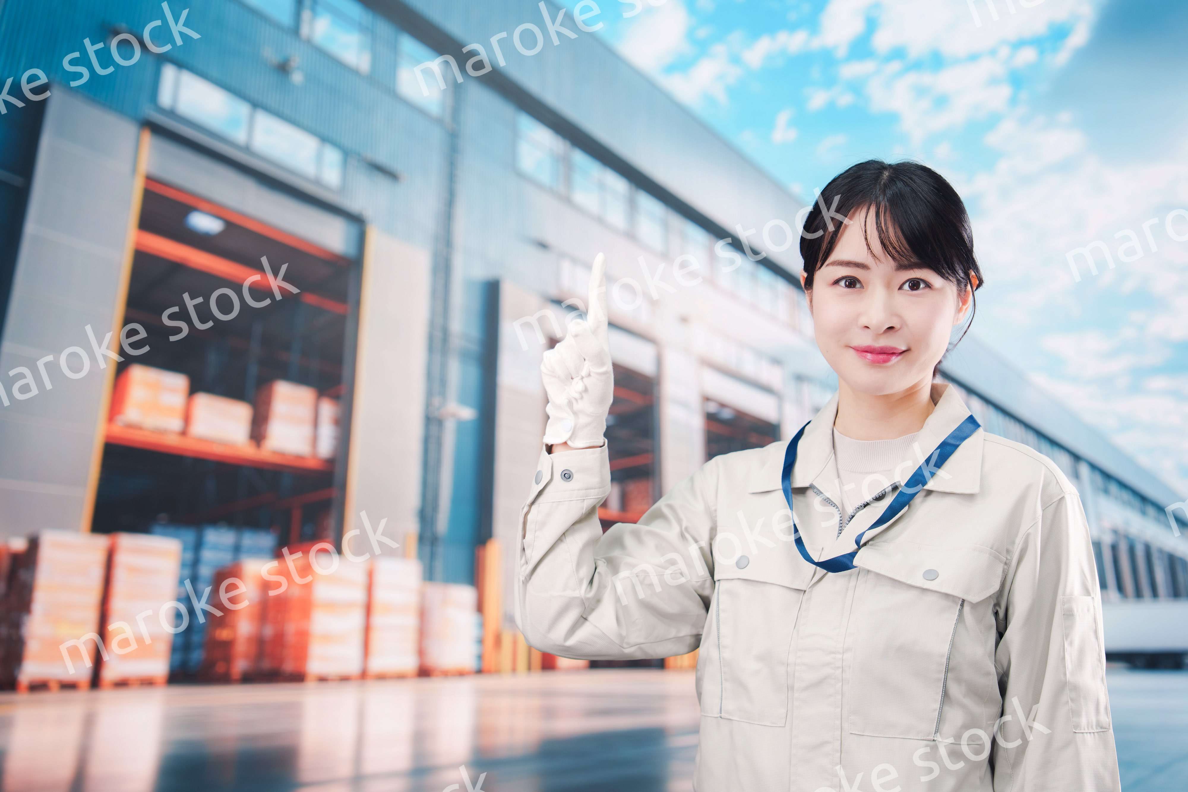 物流拠点で働く作業服姿の若い女性