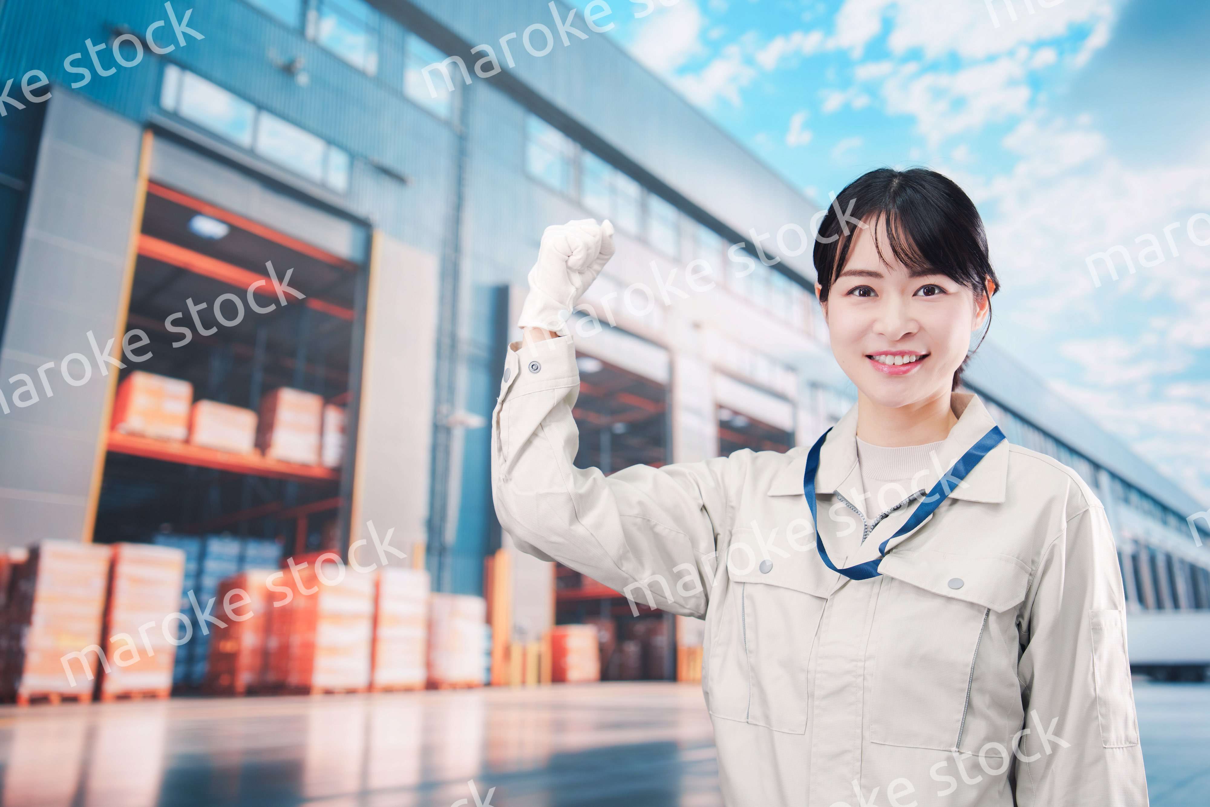 物流拠点で働く作業服姿の若い女性