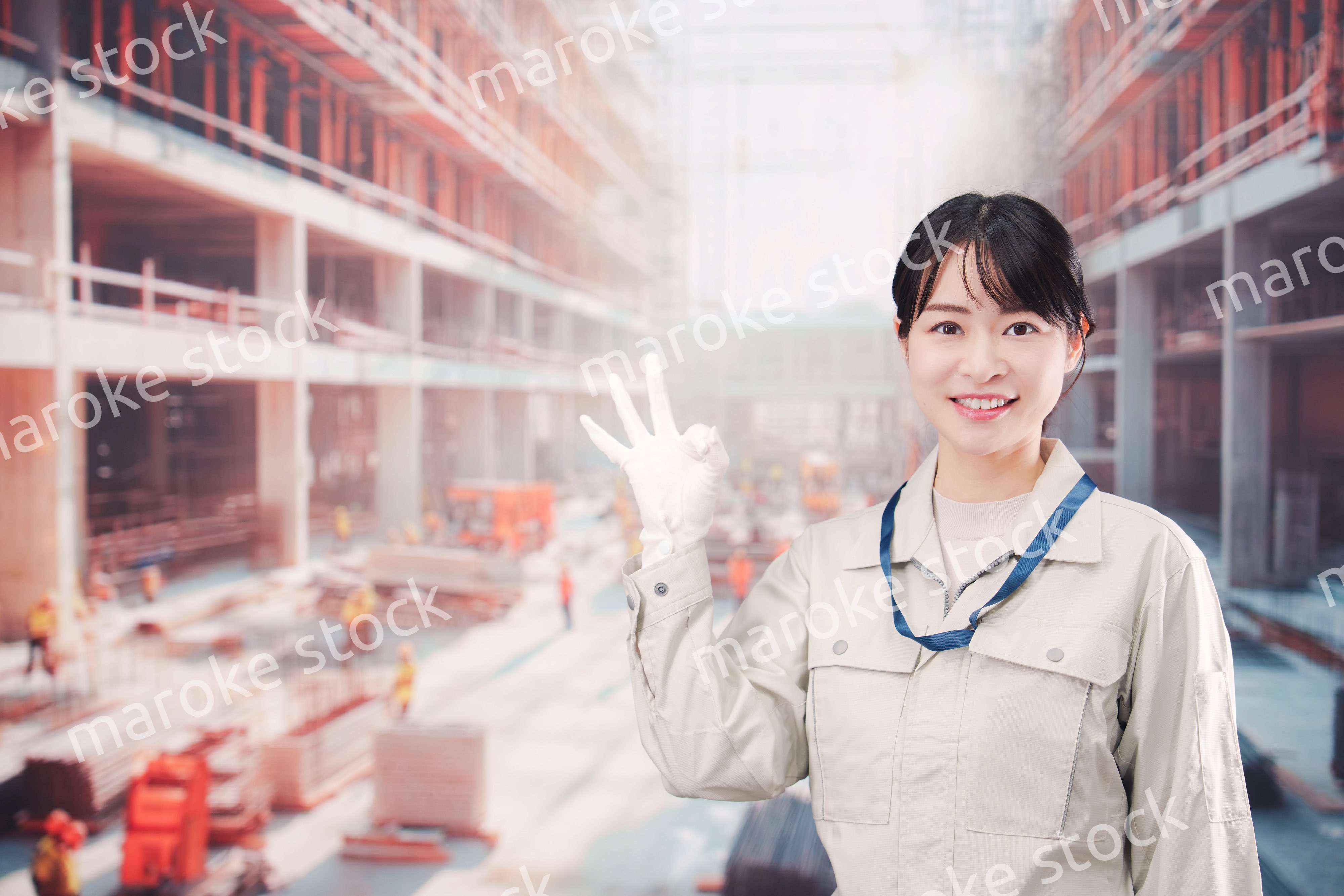 ビルの建築現場で働く作業着を着た若い女性