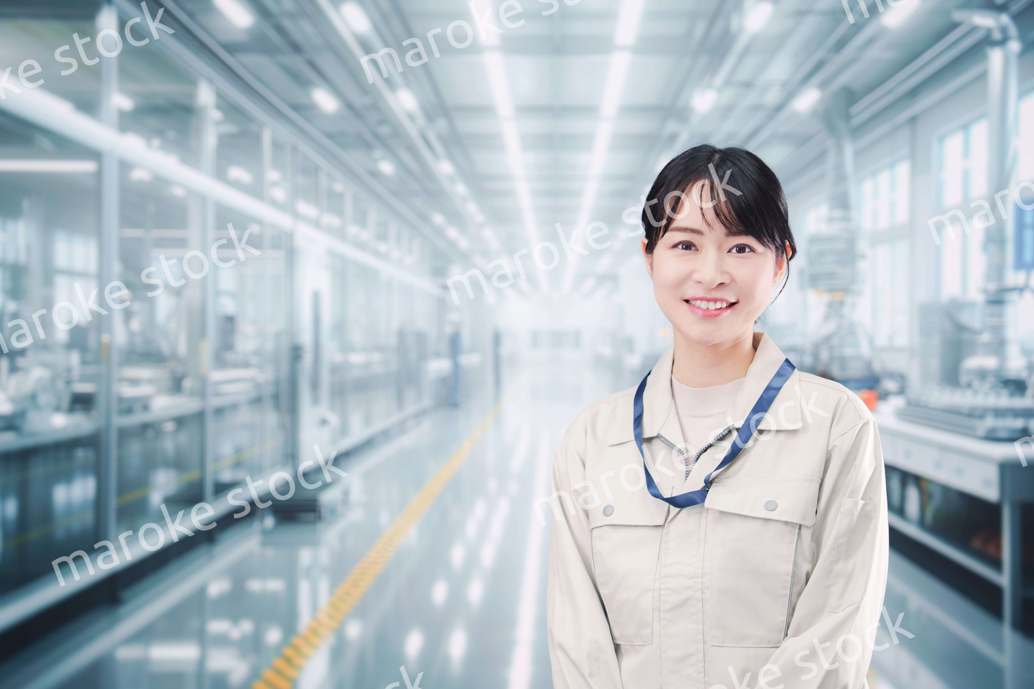 大きな工場で働く笑顔の若い女性
