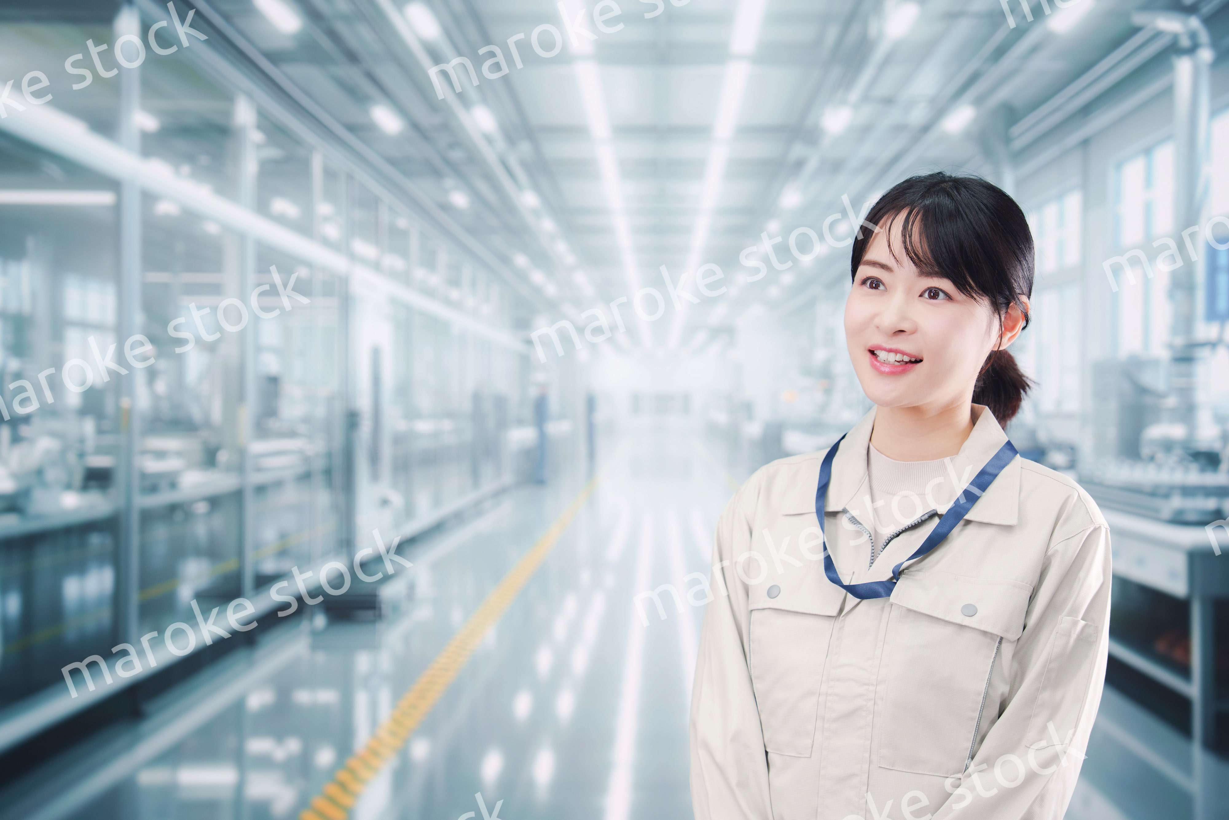 大きな工場で働く笑顔の若い女性