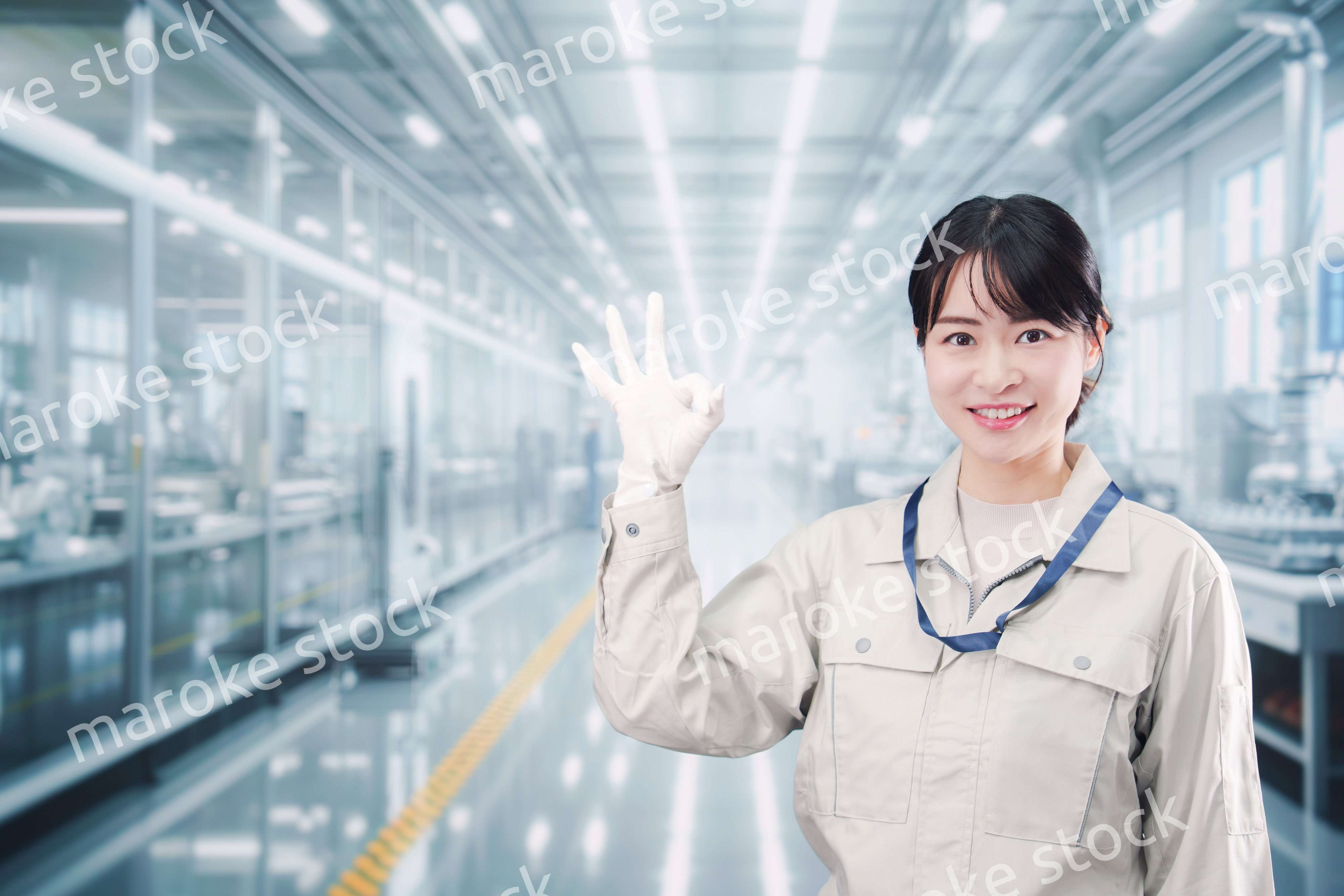 大きな工場で働く笑顔の若い女性