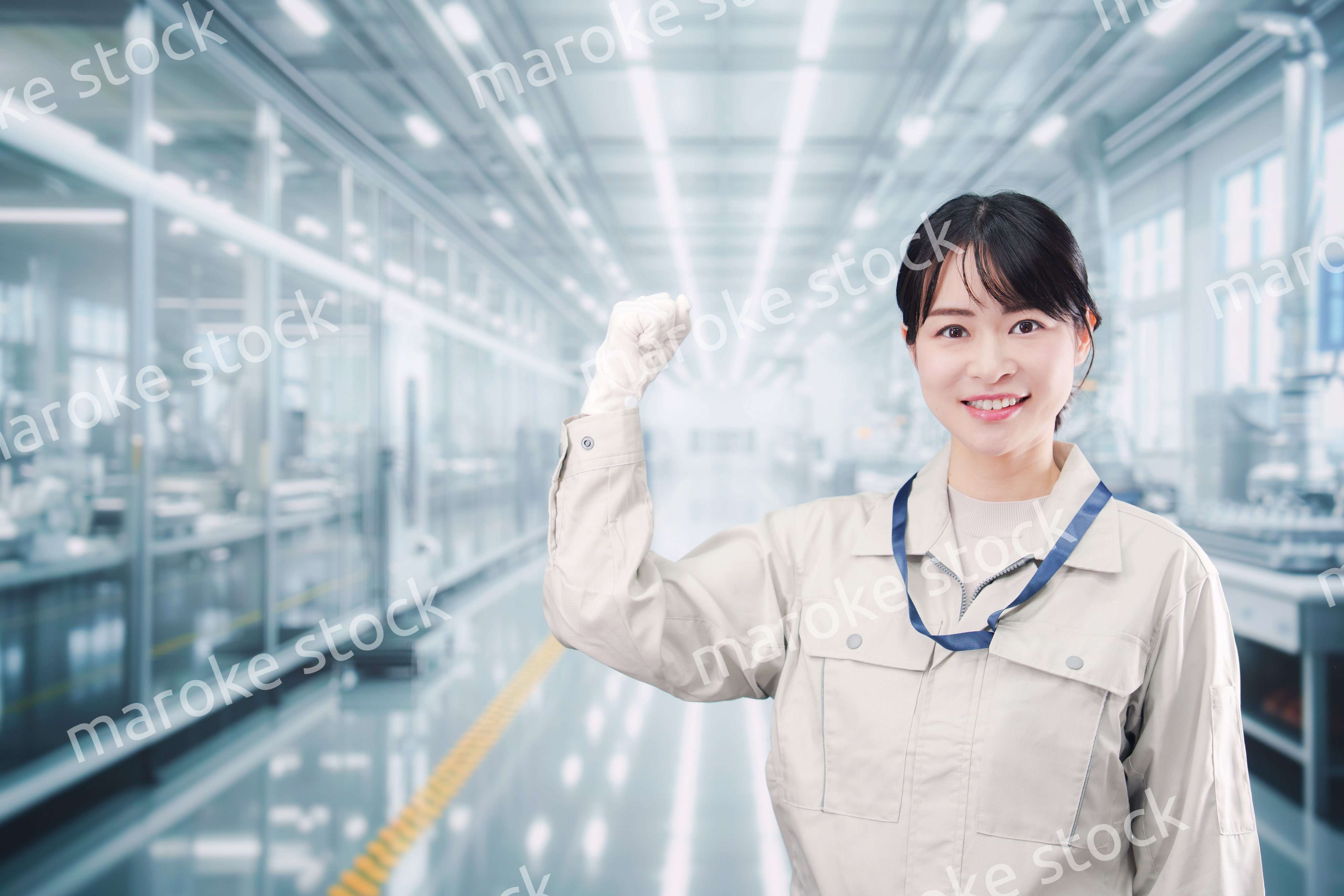 大きな工場で働く笑顔の若い女性