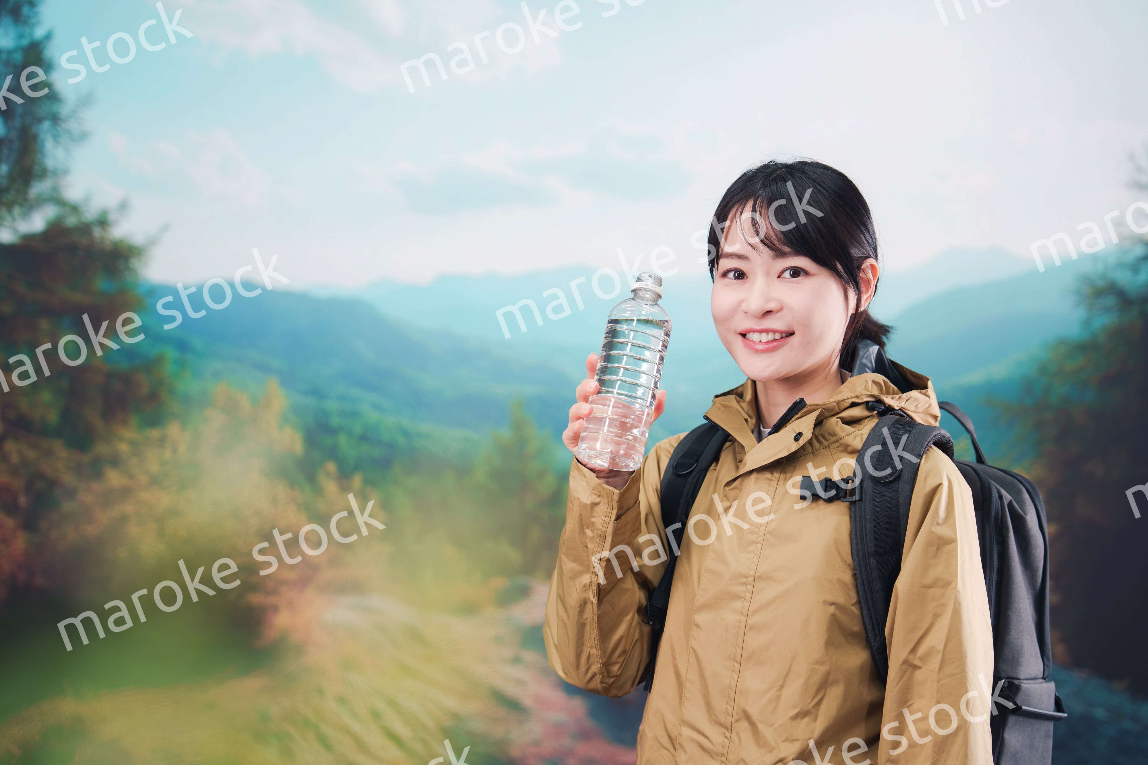登山をしながら水分補給をする若い女性
