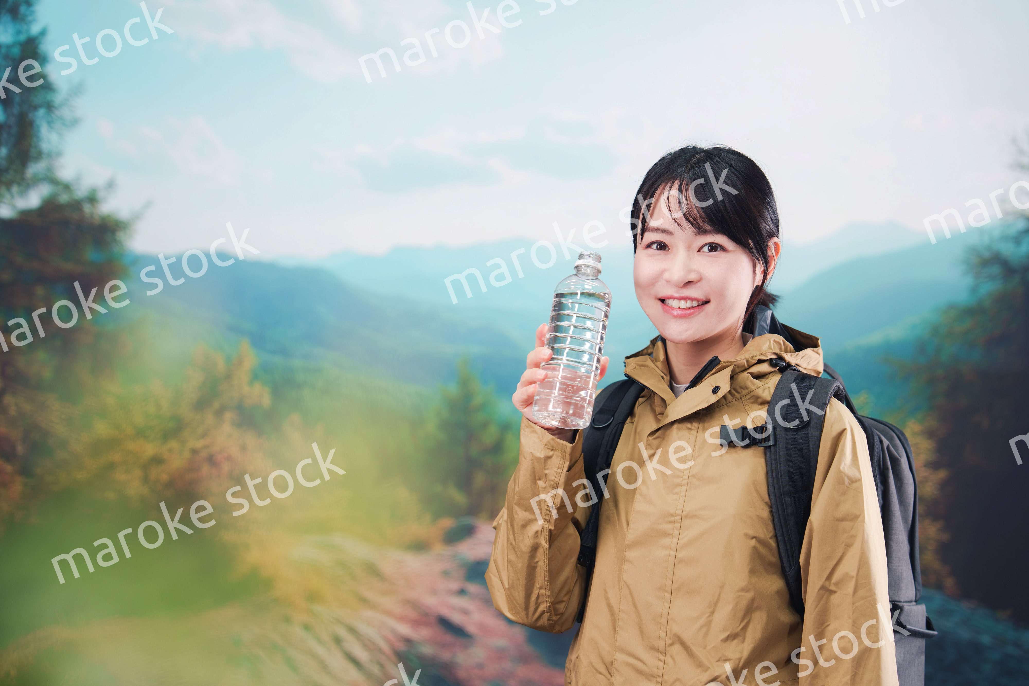 登山をしながら水分補給をする若い女性