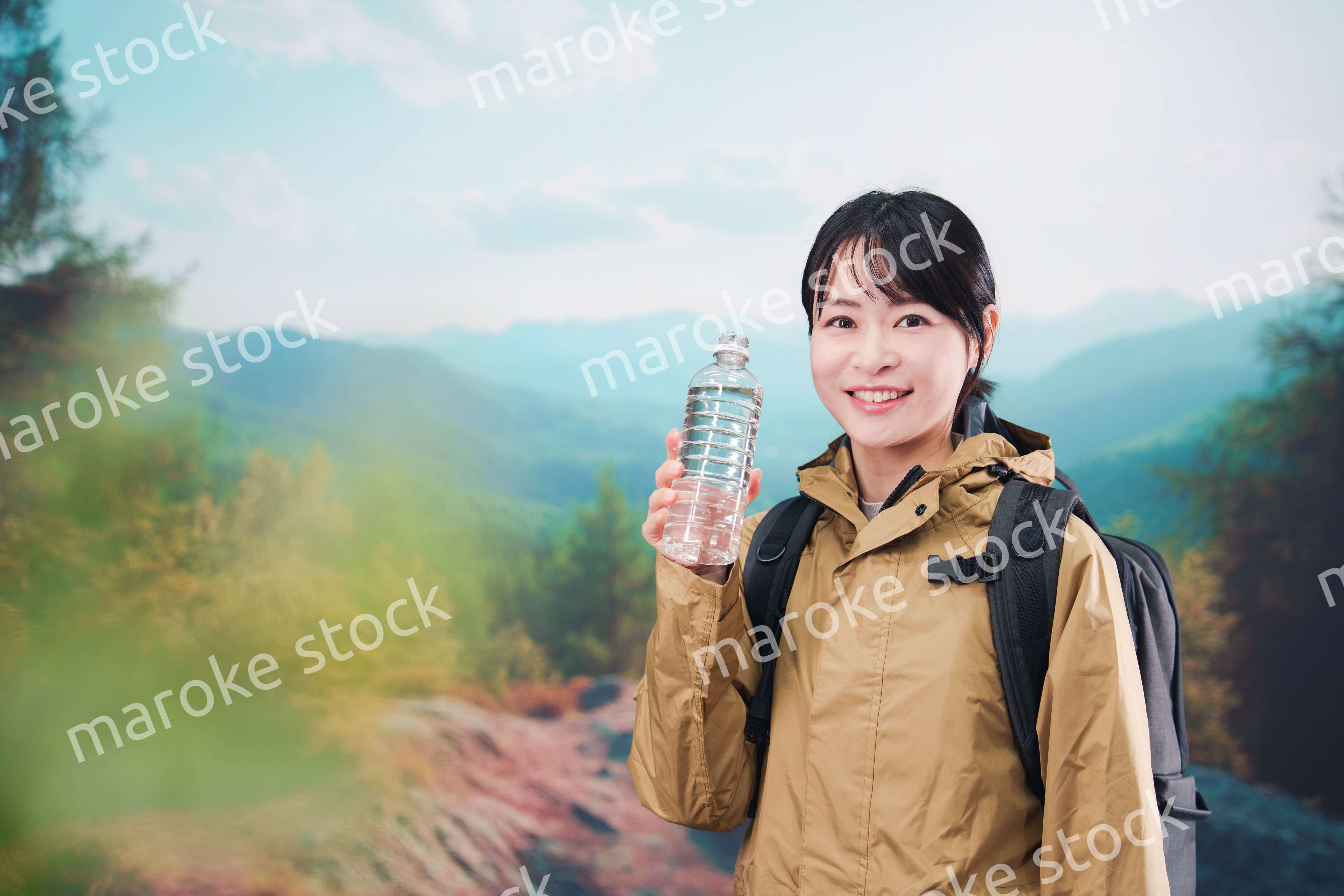 登山をしながら水分補給をする若い女性
