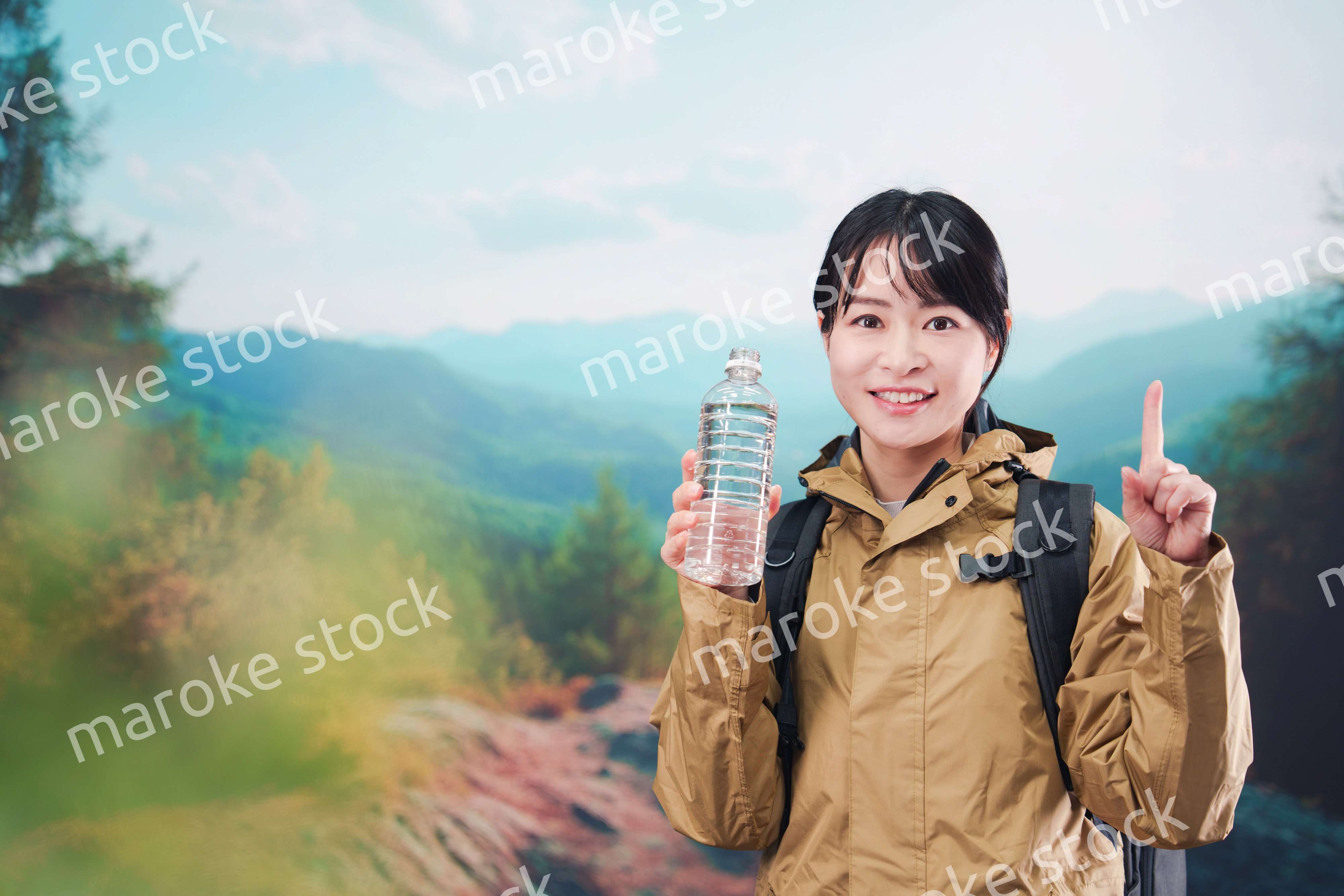 登山をしながら水分補給をする若い女性