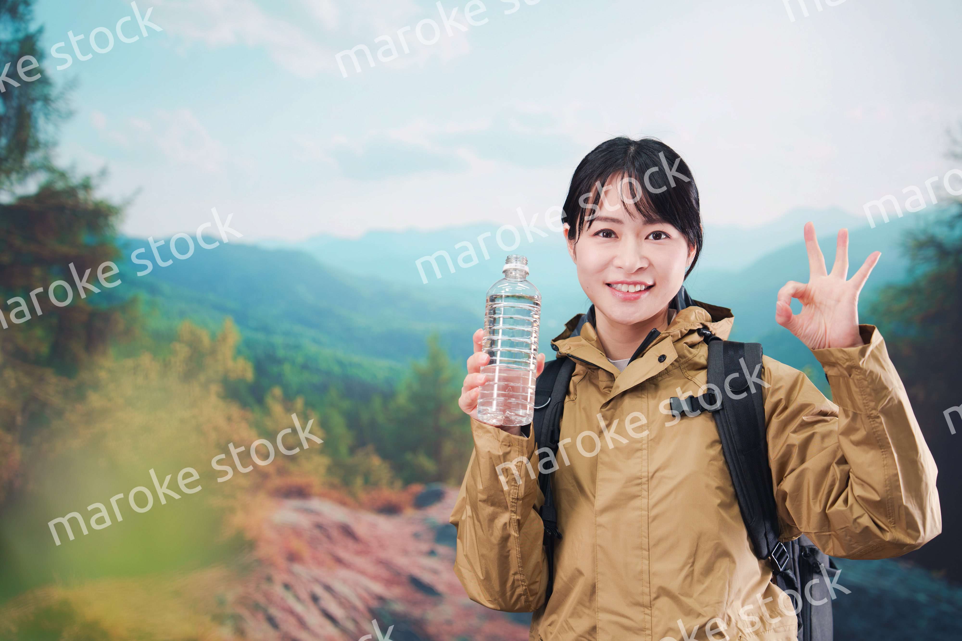 登山をしながら水分補給をする若い女性