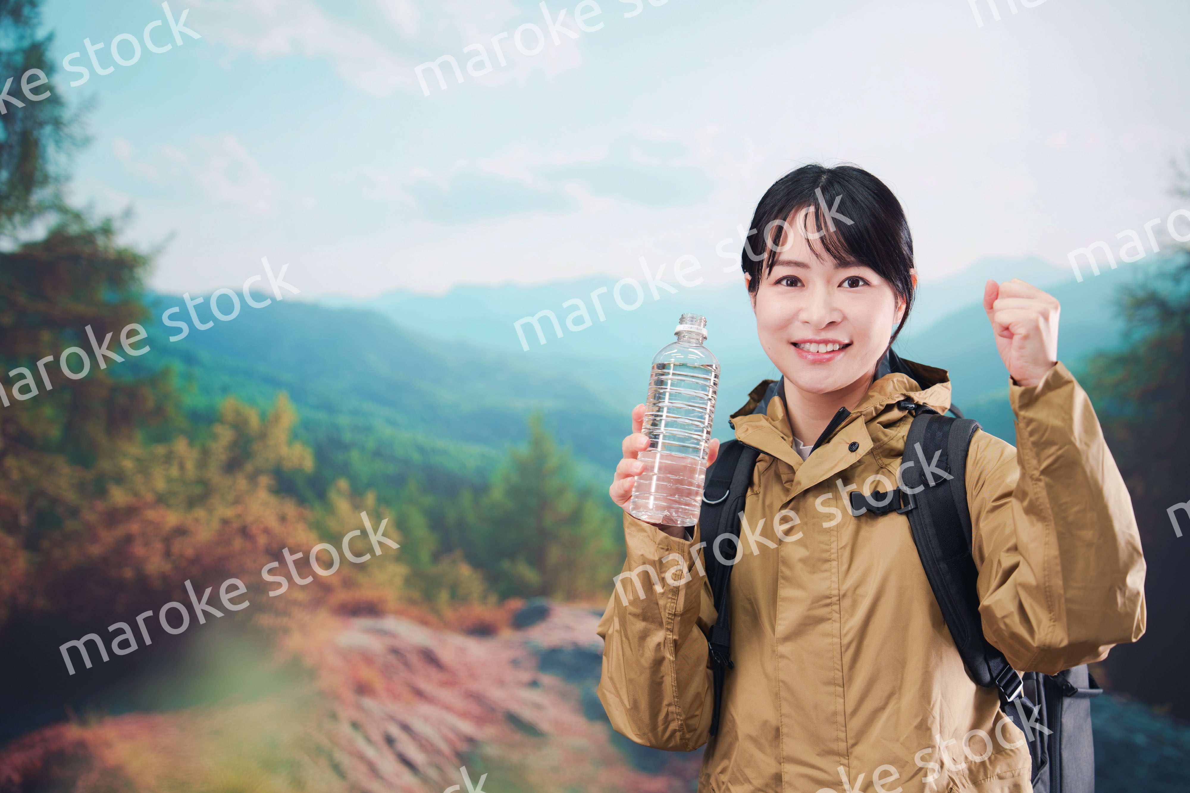 登山をしながら水分補給をする若い女性