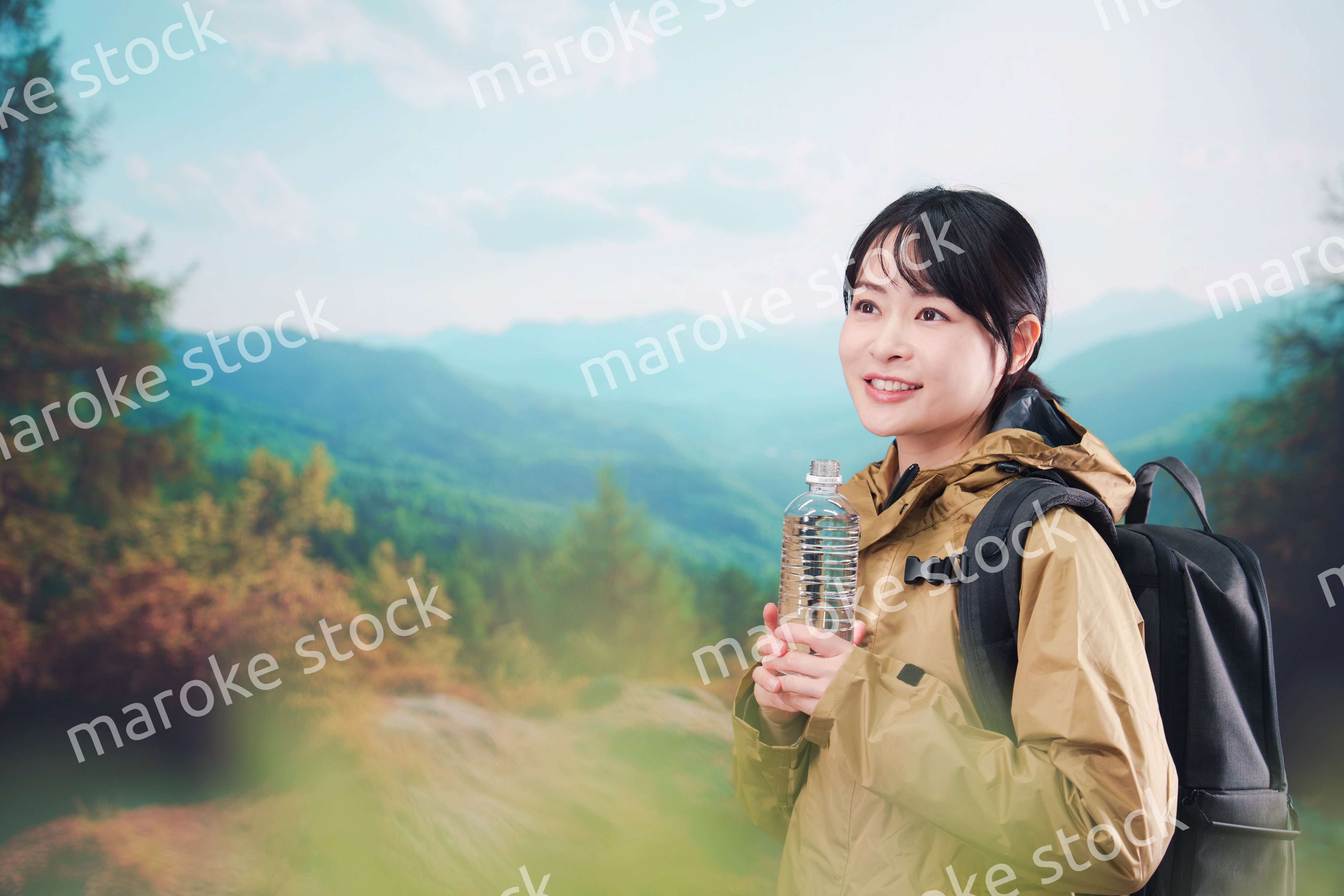 登山をしながら水分補給をする若い女性