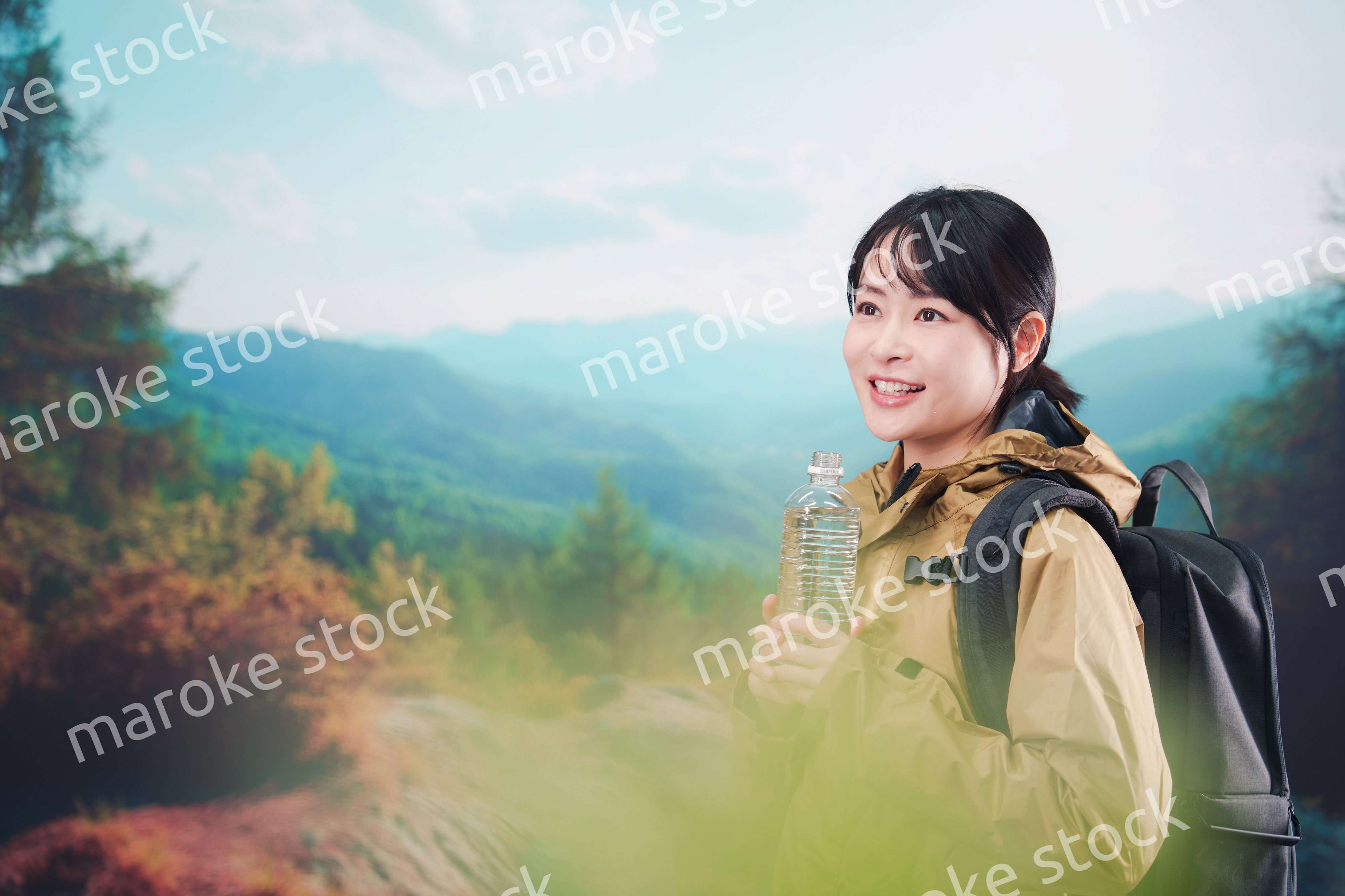 登山をしながら水分補給をする若い女性