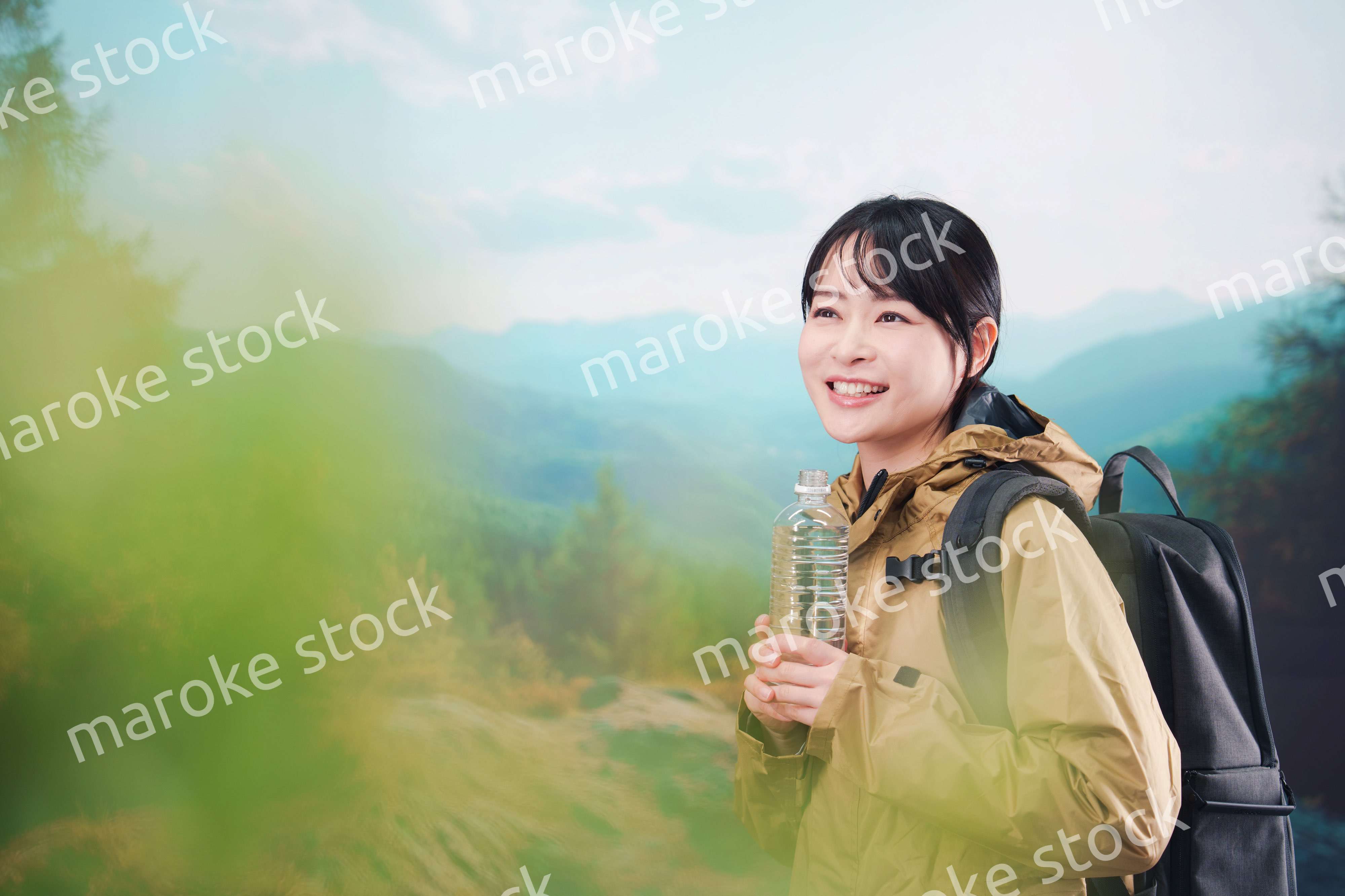 登山をしながら水分補給をする若い女性