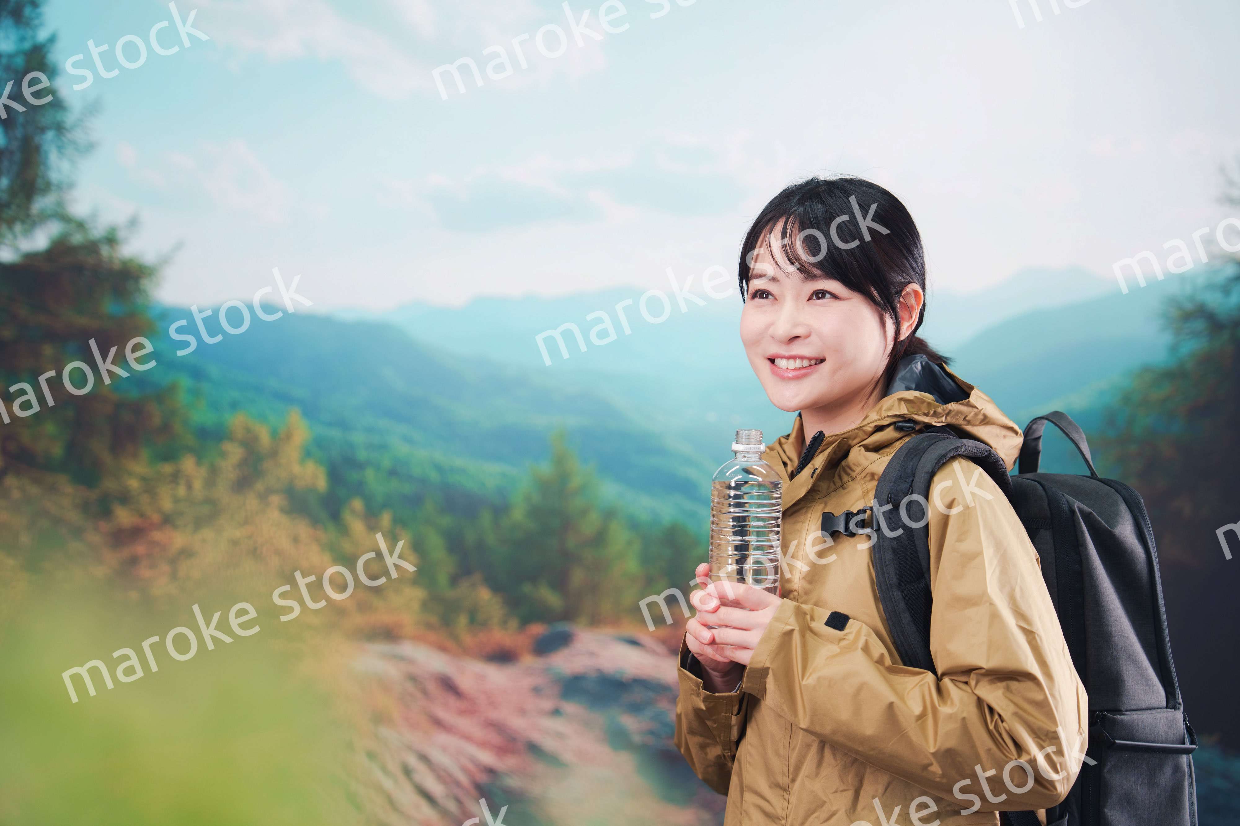 登山をしながら水分補給をする若い女性
