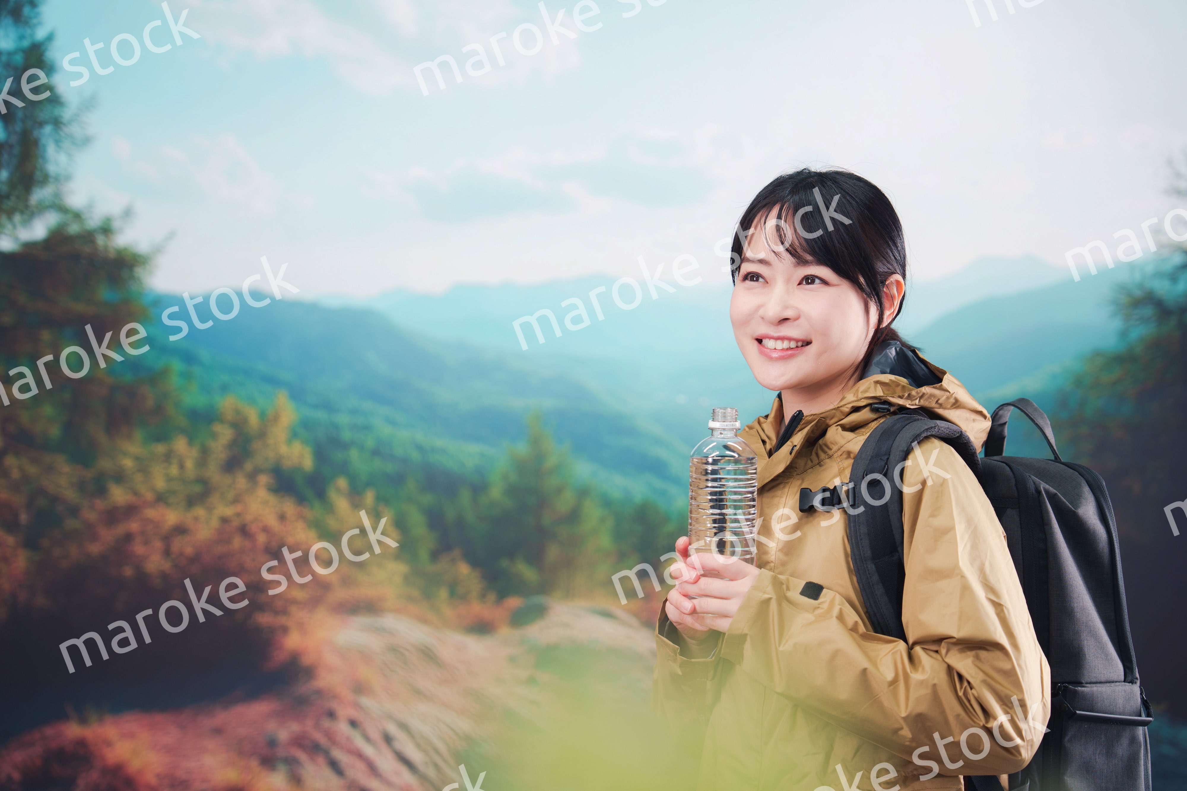 登山をしながら水分補給をする若い女性