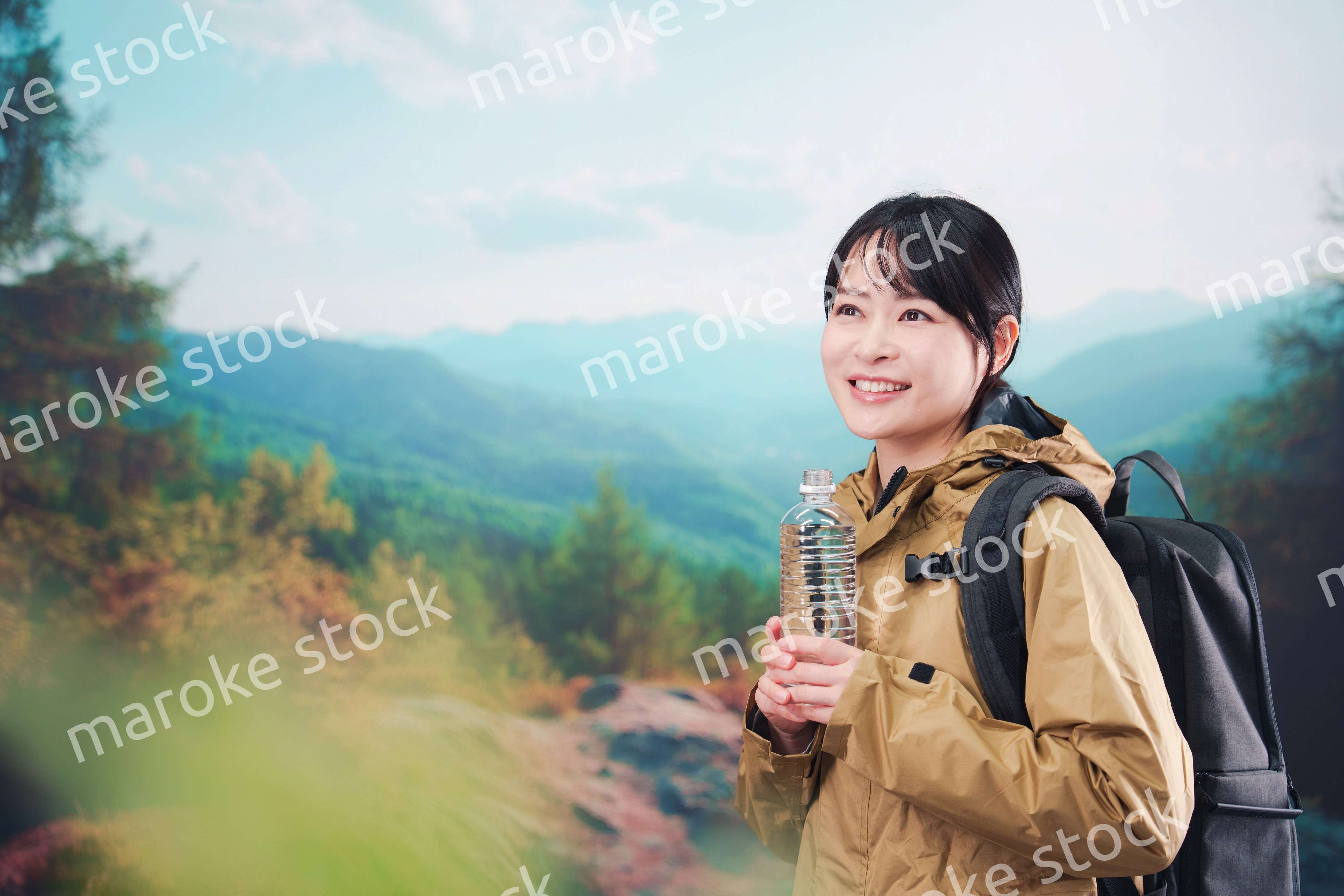 登山をしながら水分補給をする若い女性