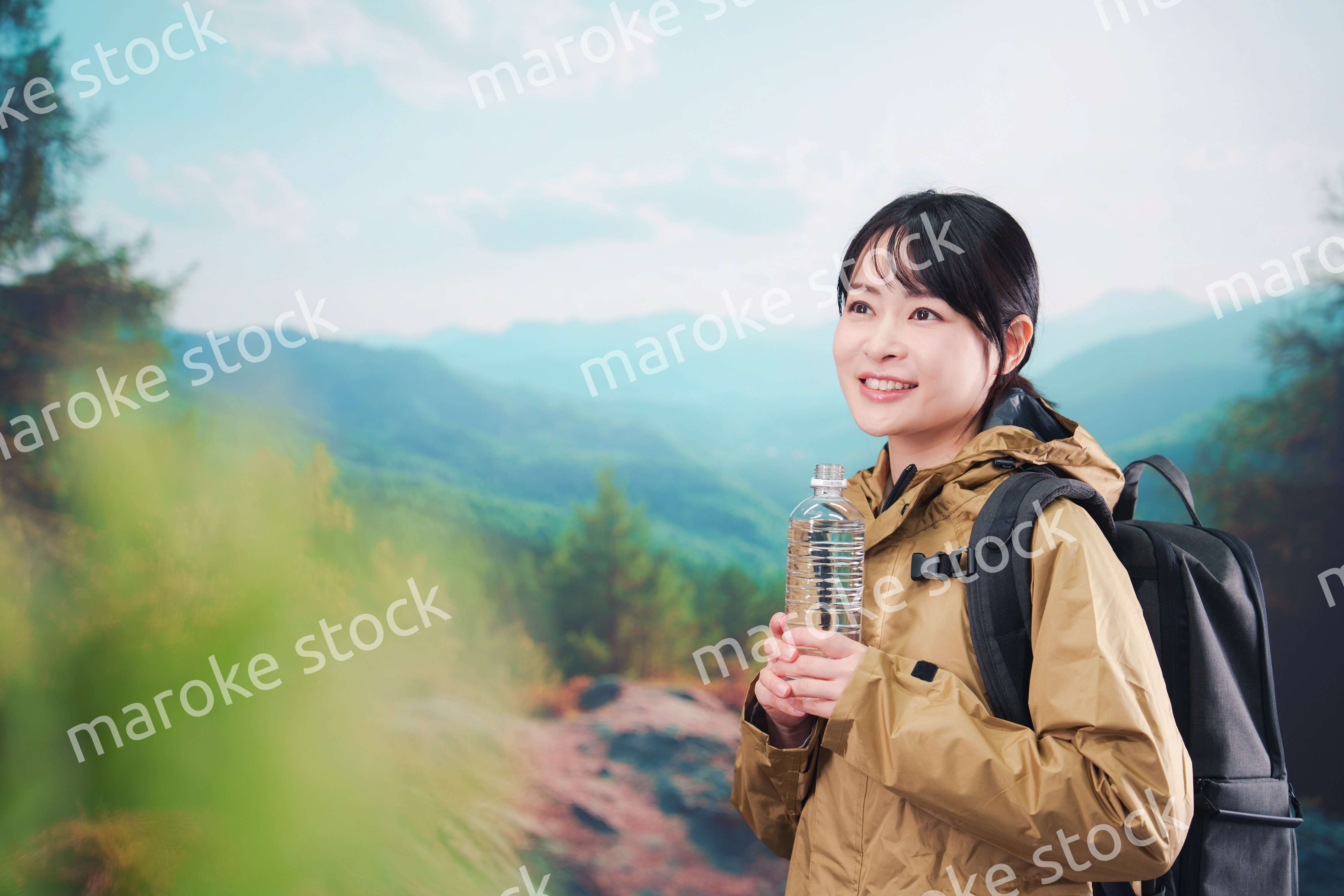 登山をしながら水分補給をする若い女性