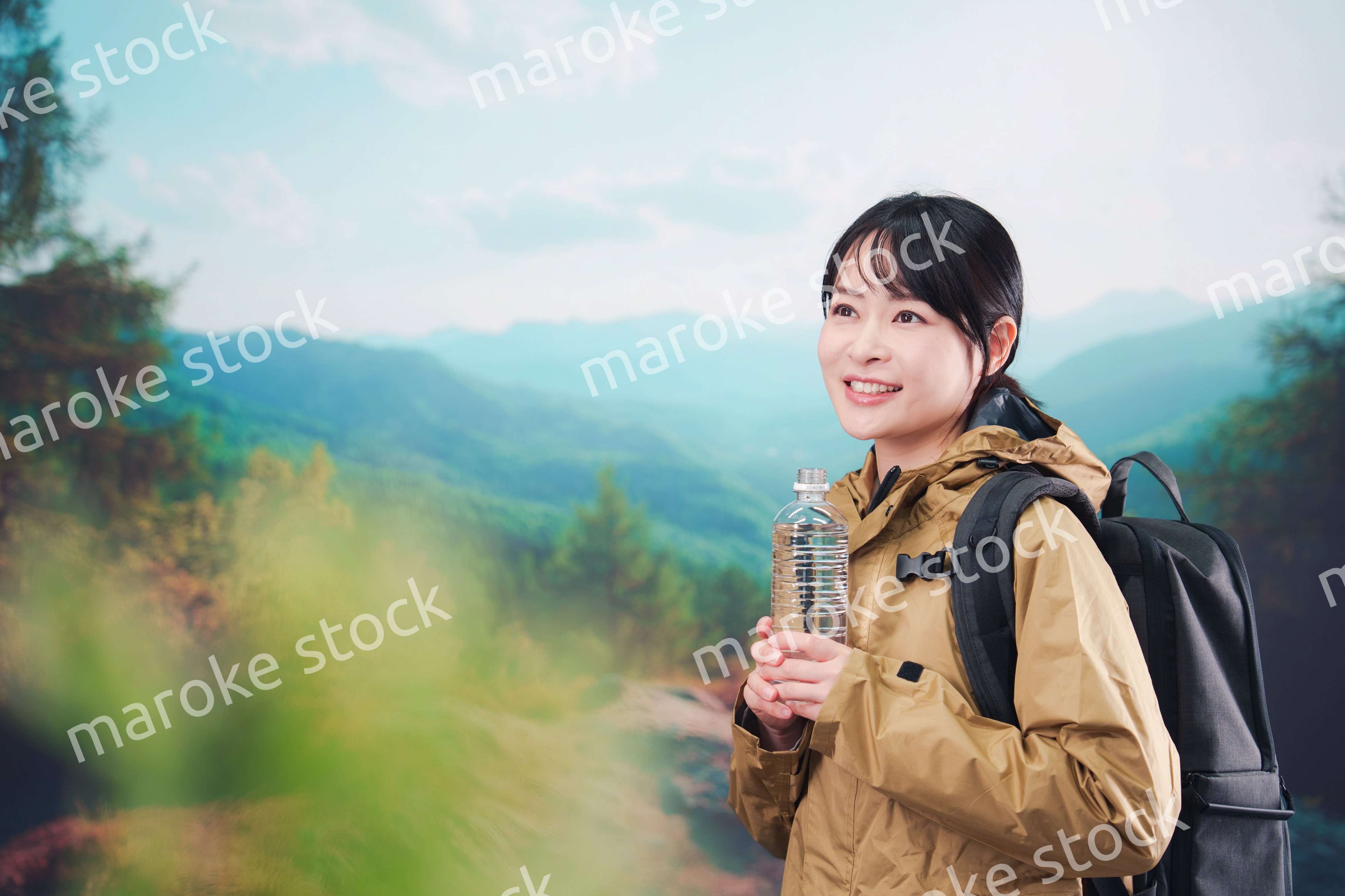 登山をしながら水分補給をする若い女性