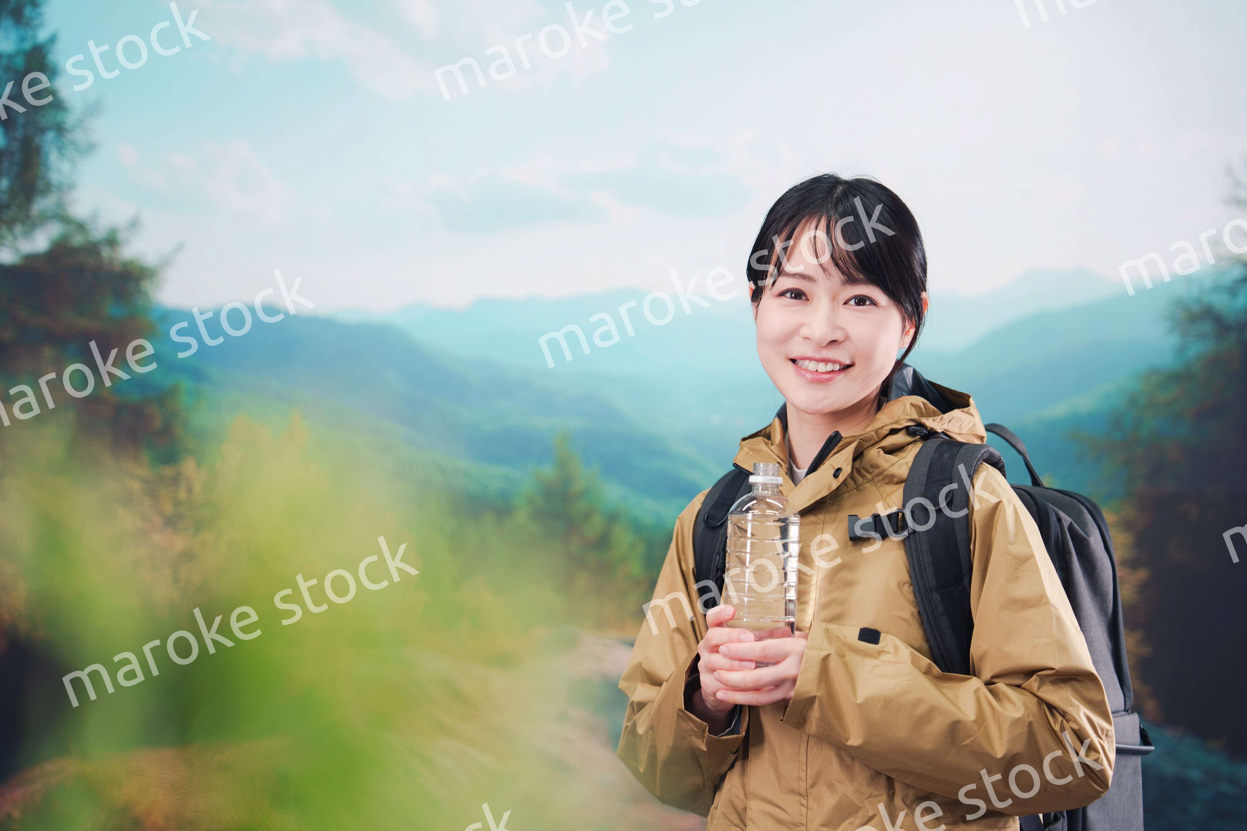 登山をしながら水分補給をする若い女性