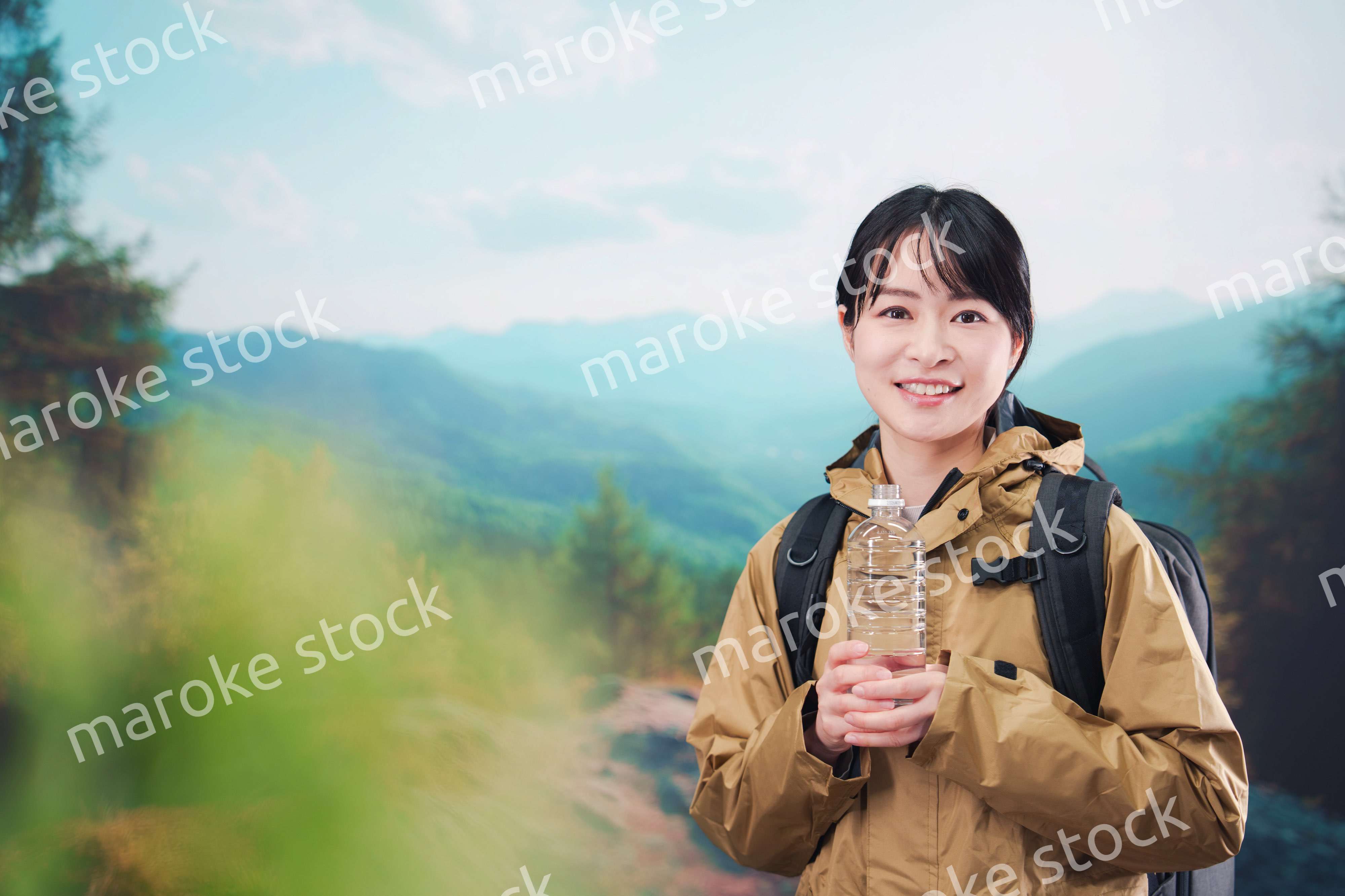 登山をしながら水分補給をする若い女性