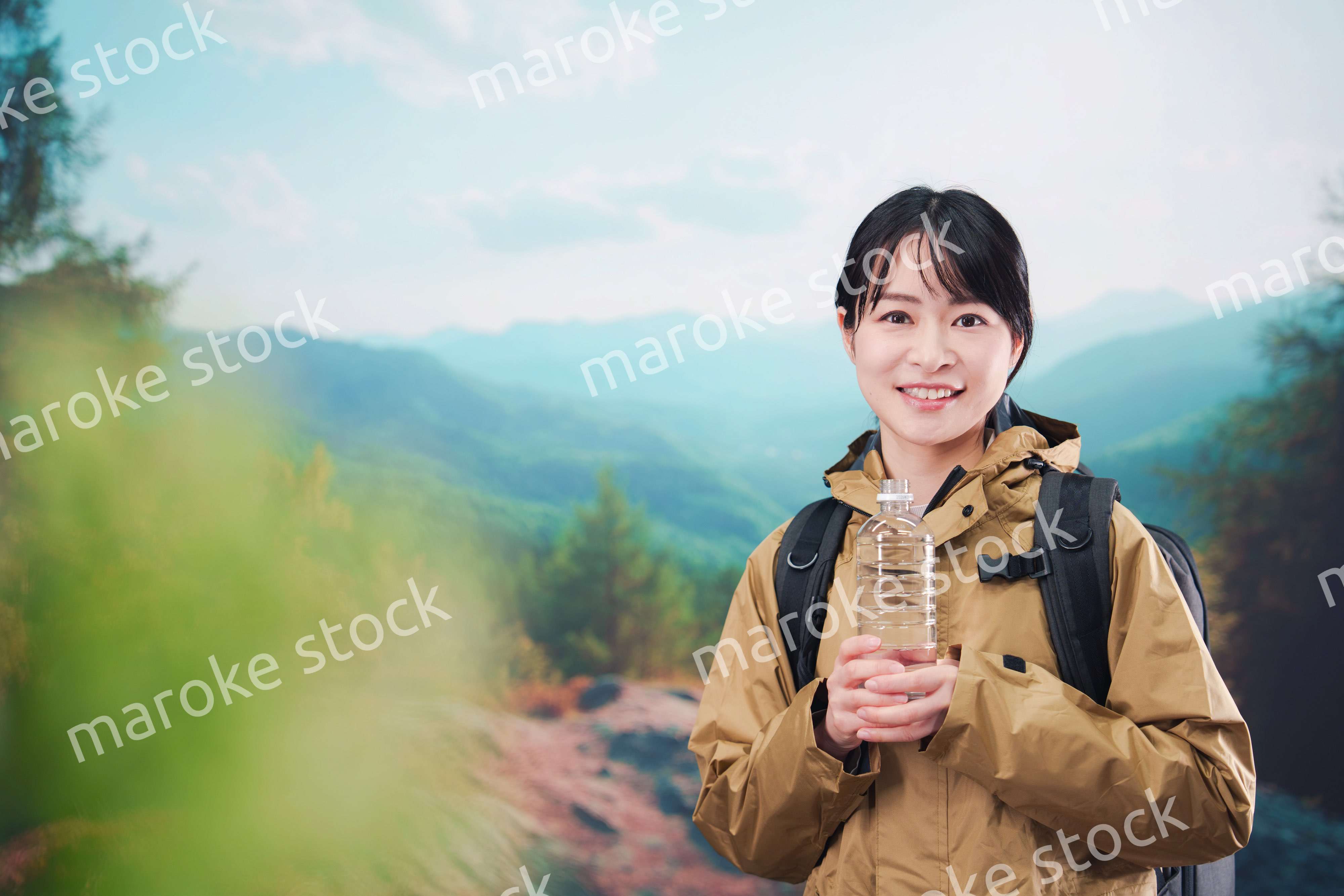 登山をしながら水分補給をする若い女性