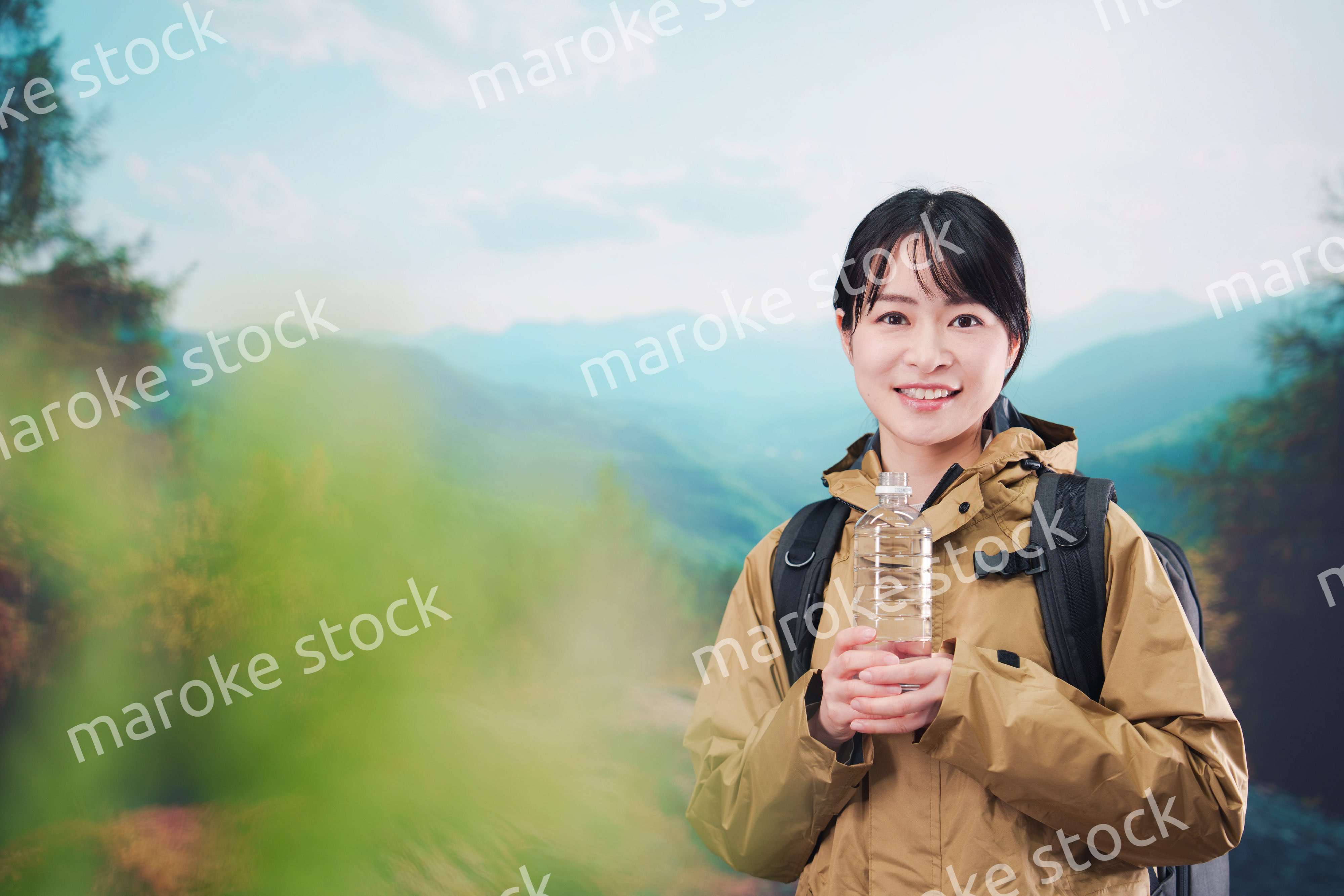 登山をしながら水分補給をする若い女性